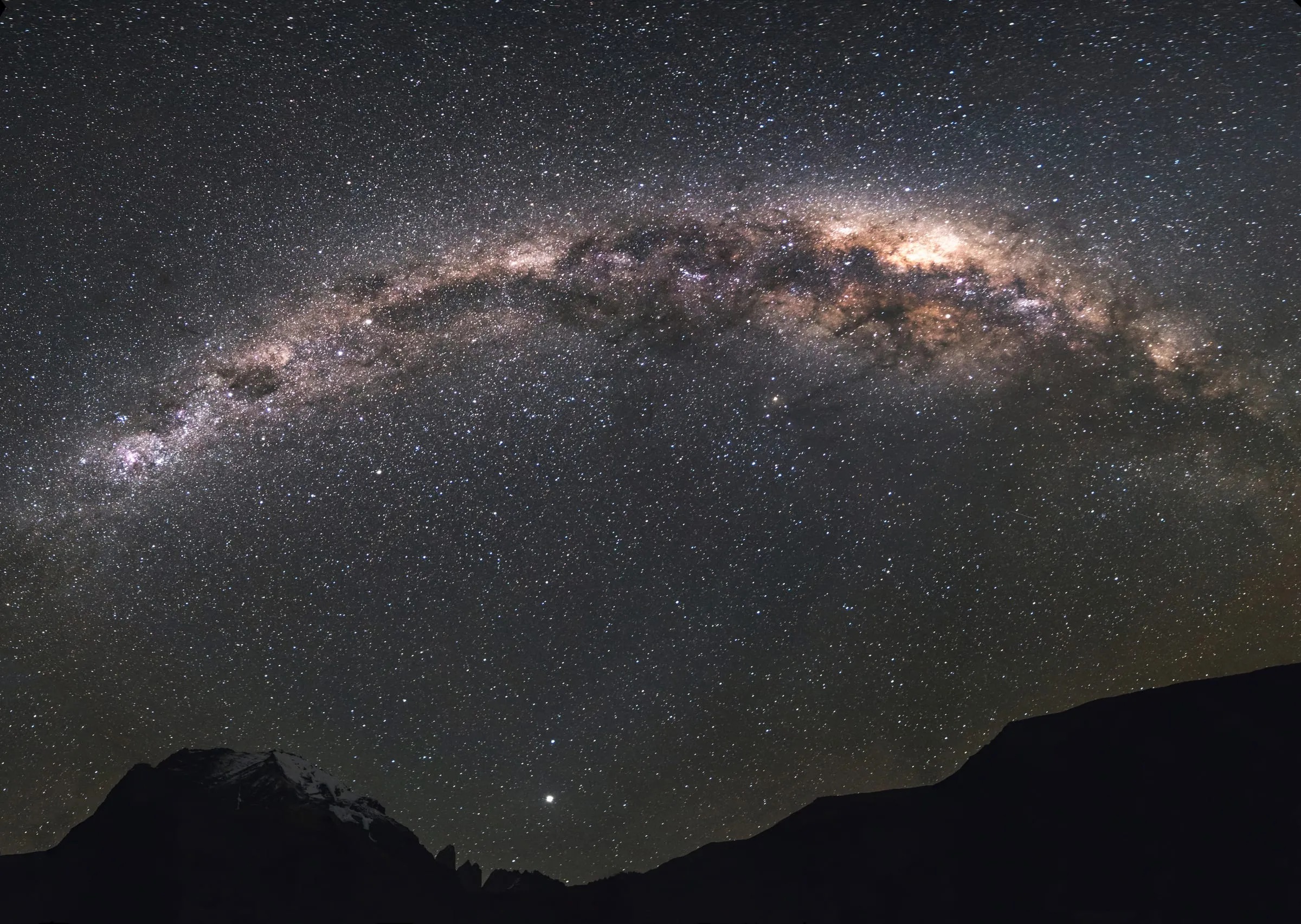 The Milky Way arching over a dark landscape