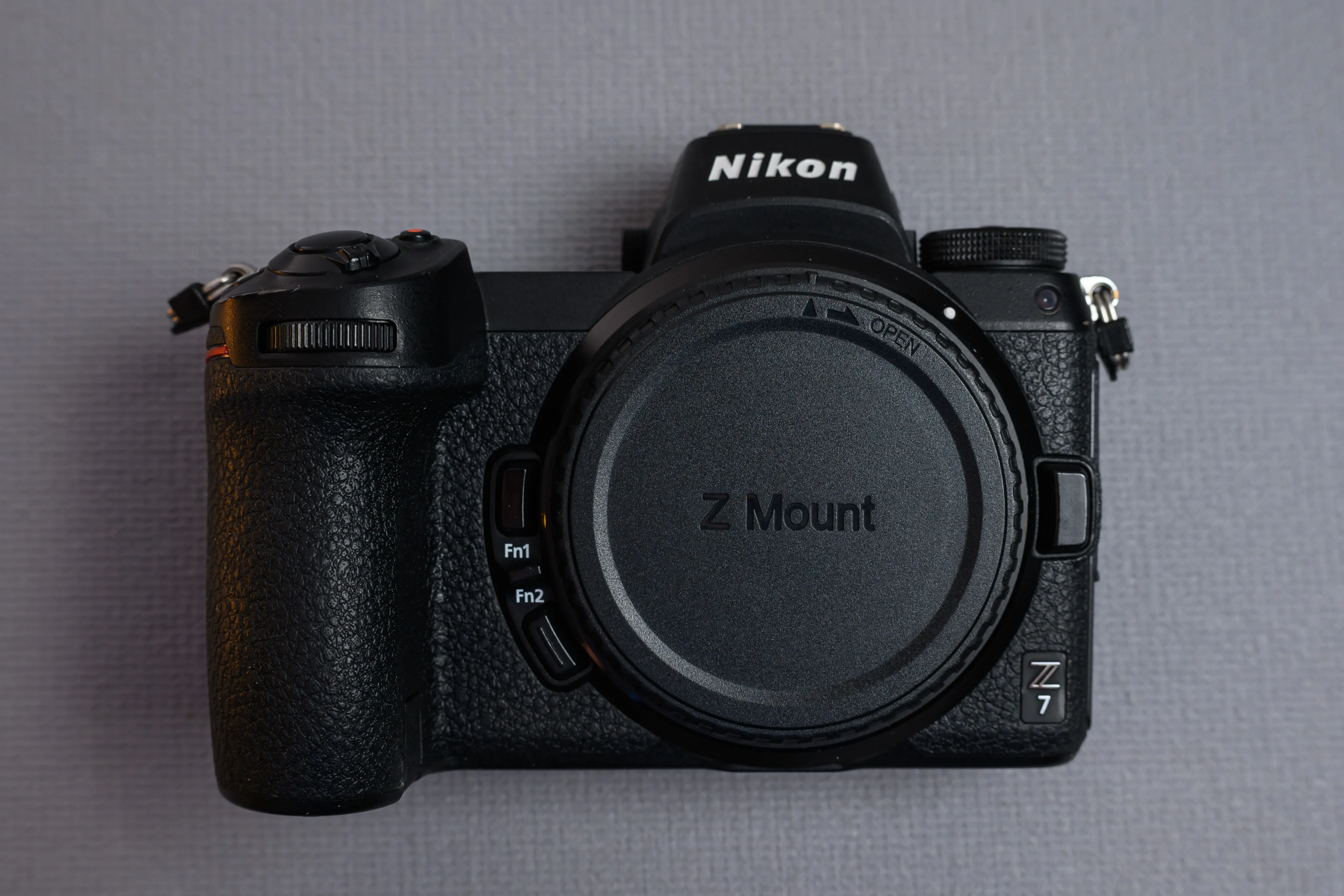 A mirrorless camera body photographed against gray fabric