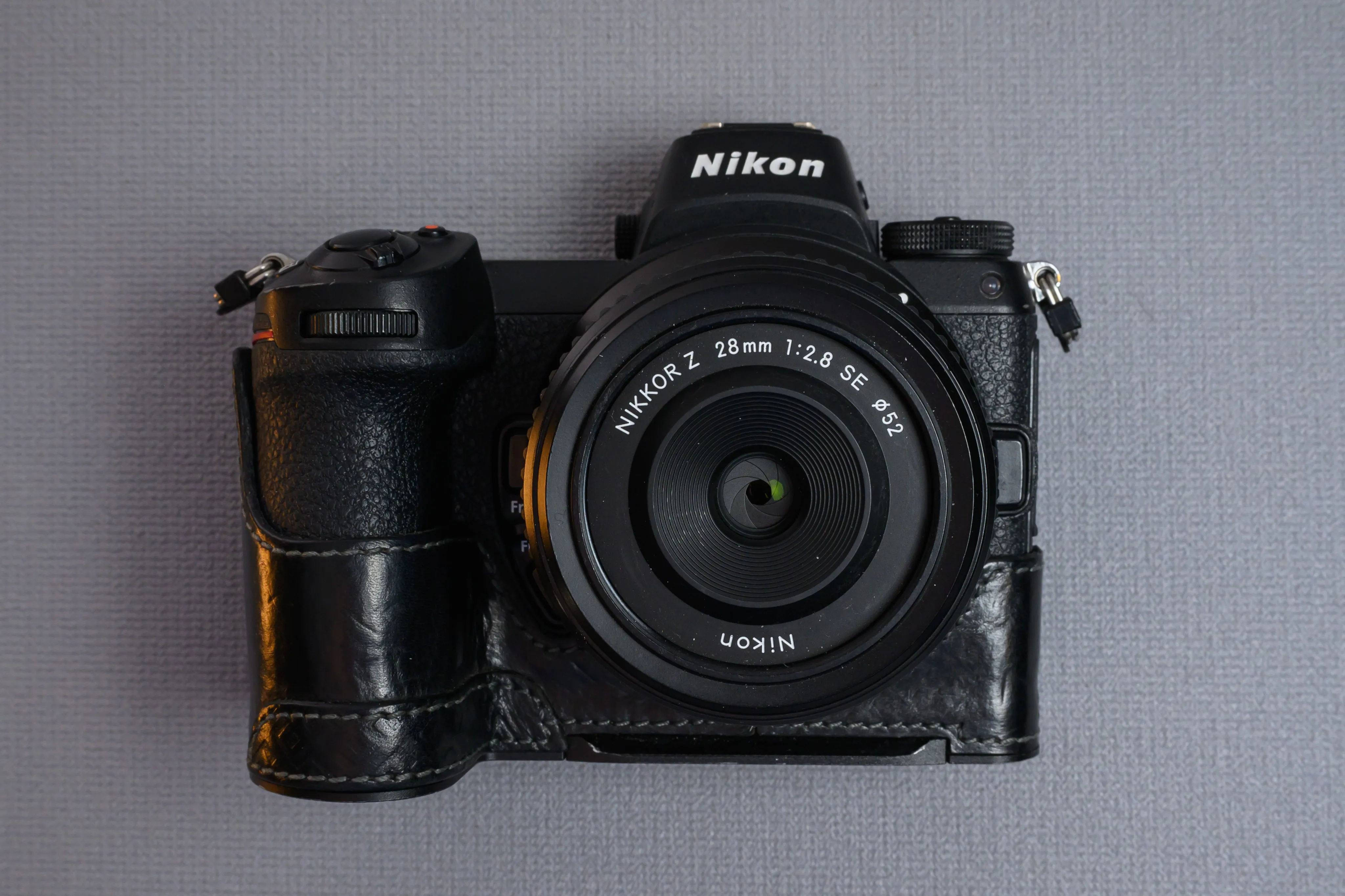 A camera with a mounted lens against a neutral backdrop