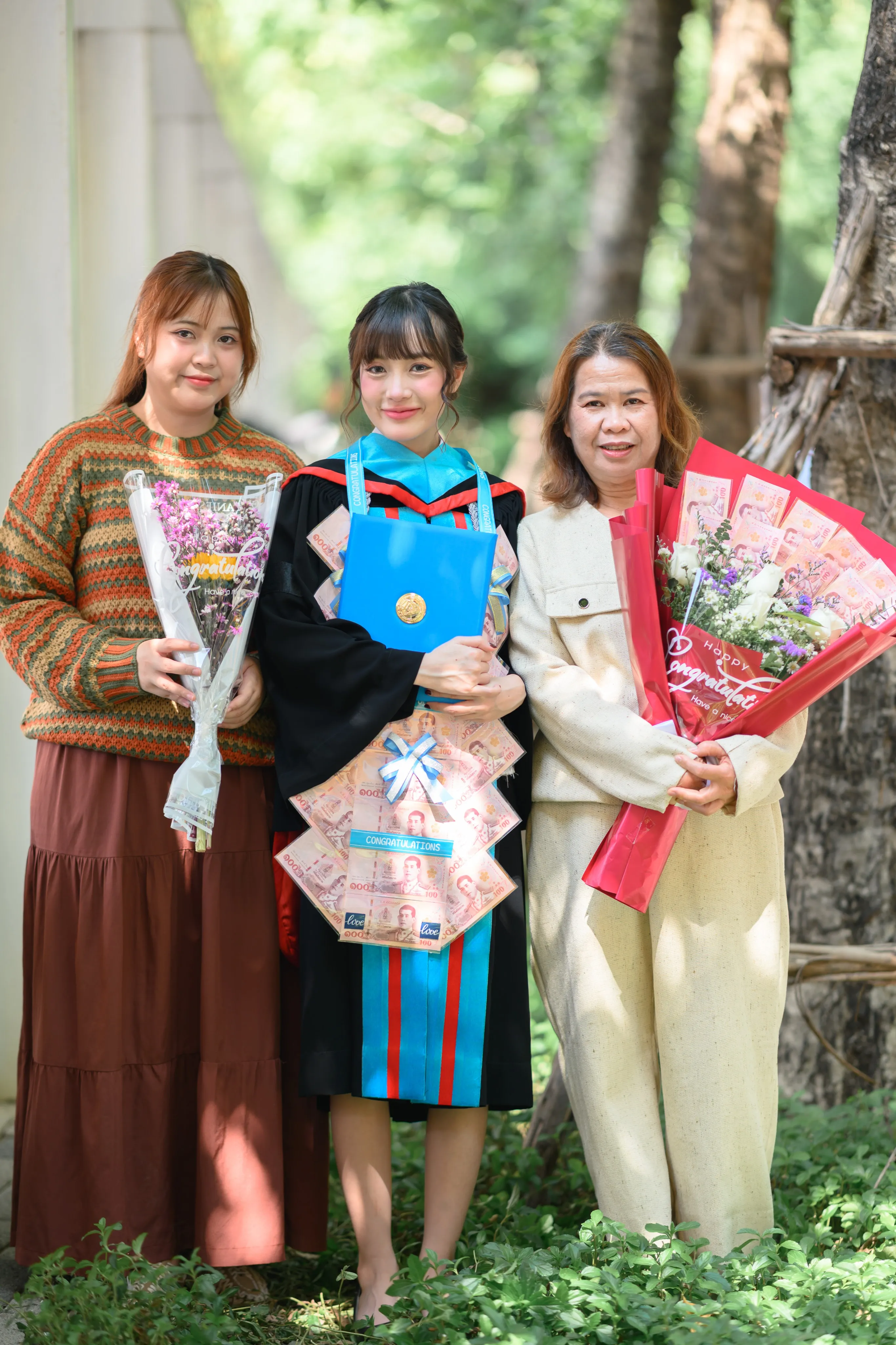A graduate celebrating with family and flowers outdoors