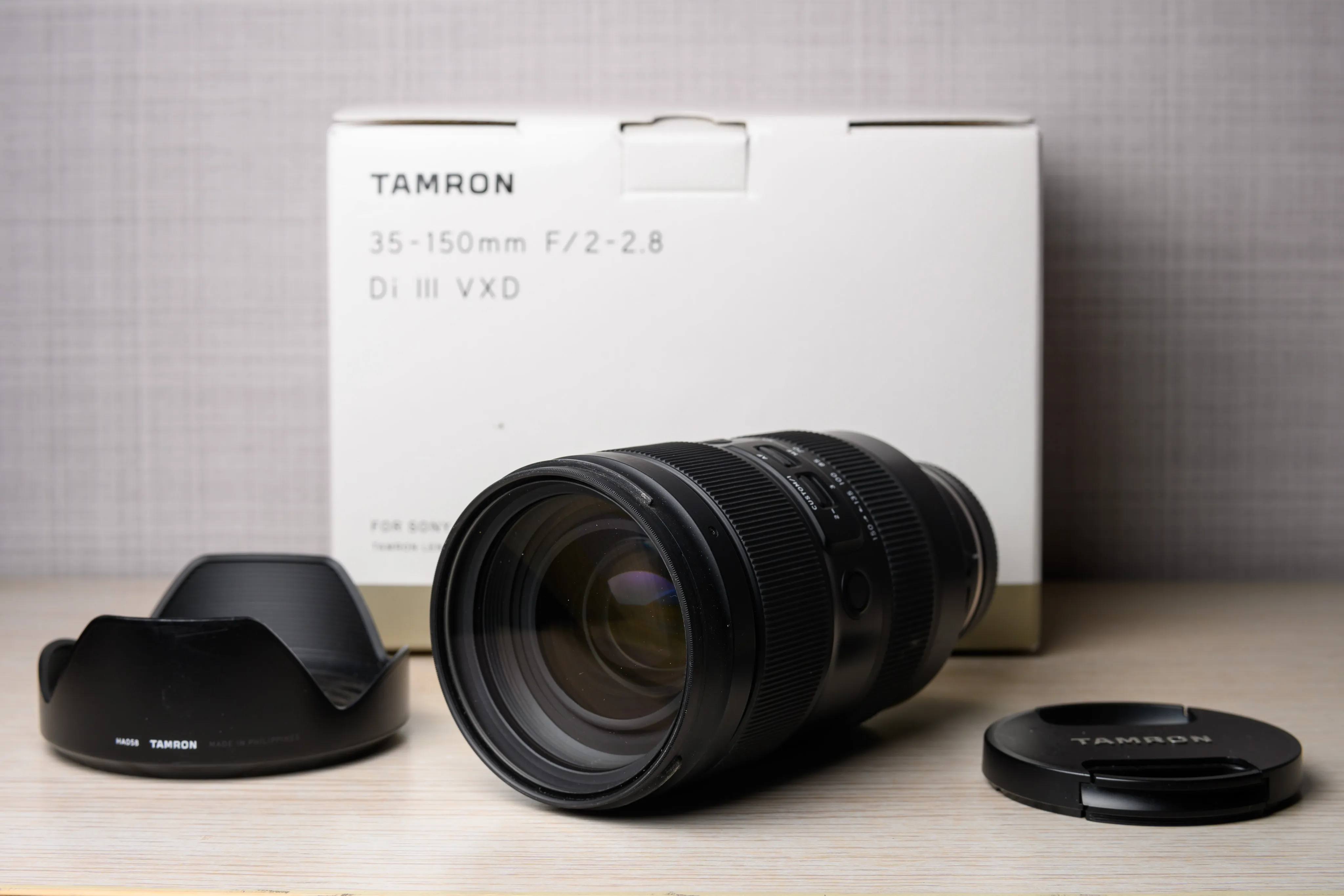 A zoom lens displayed with its box and lens caps
