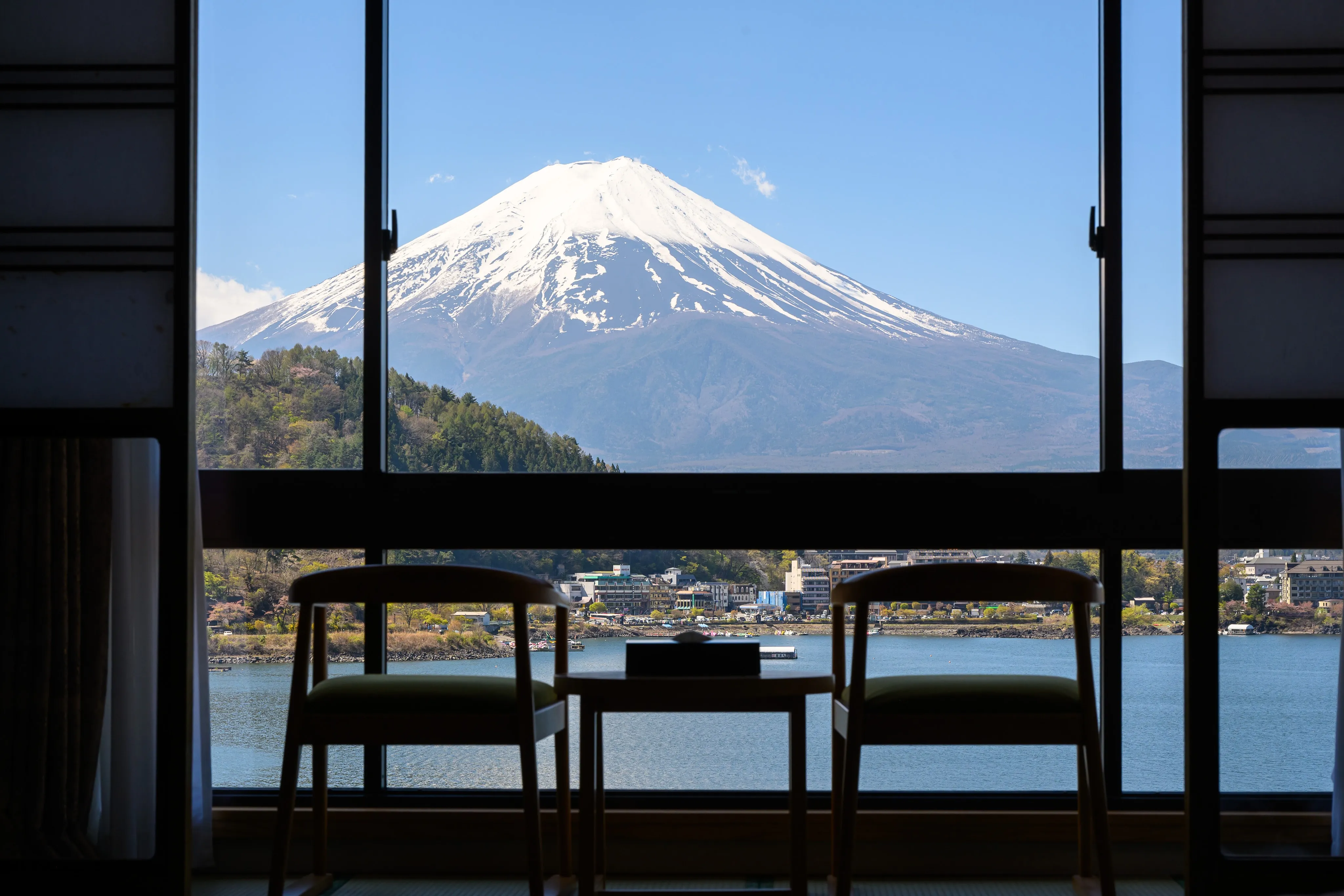 Snow-capped Mount Fuji seen across water through a large window