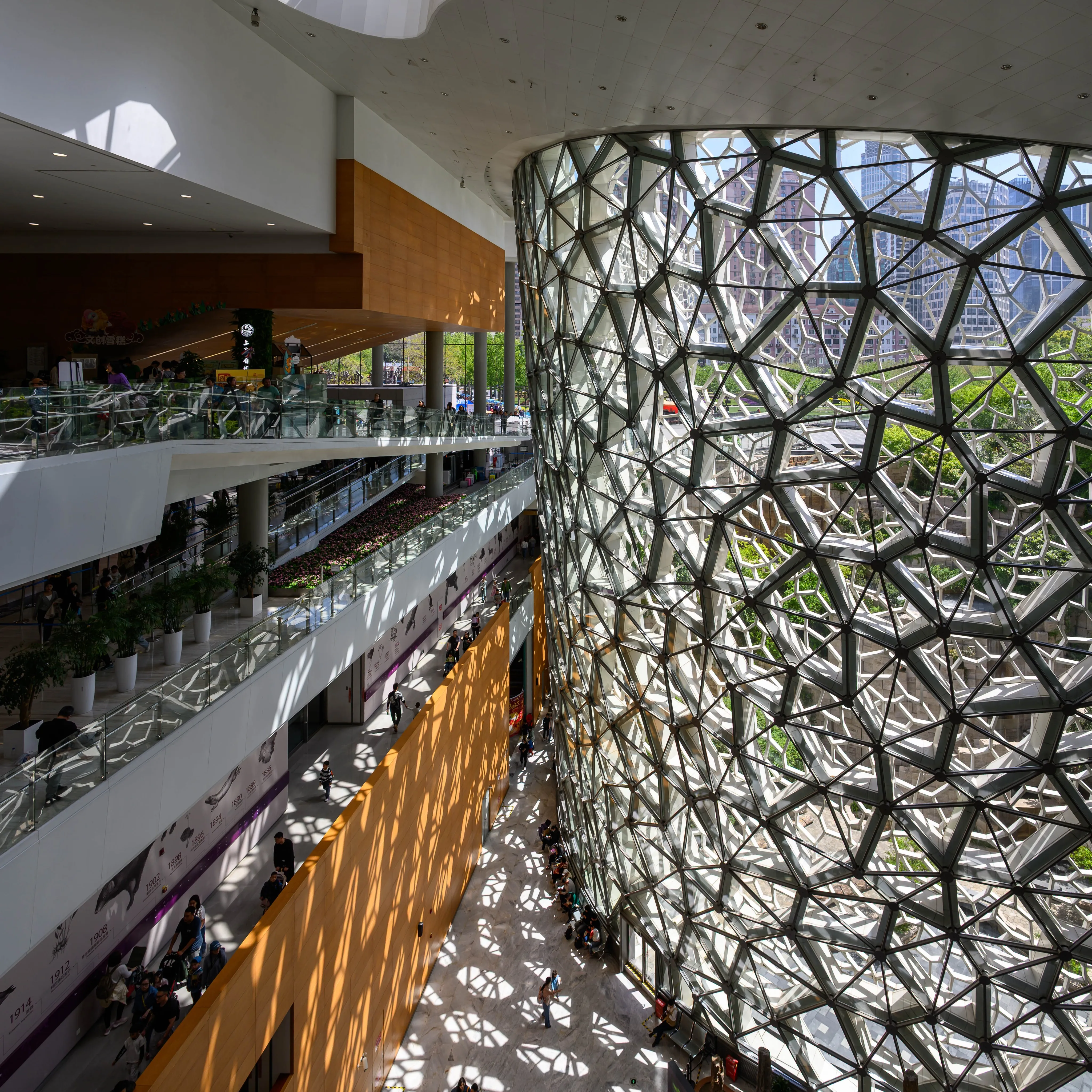 A multi-level atrium wrapped around a cylinder of organic lattice that casts patterned shadows