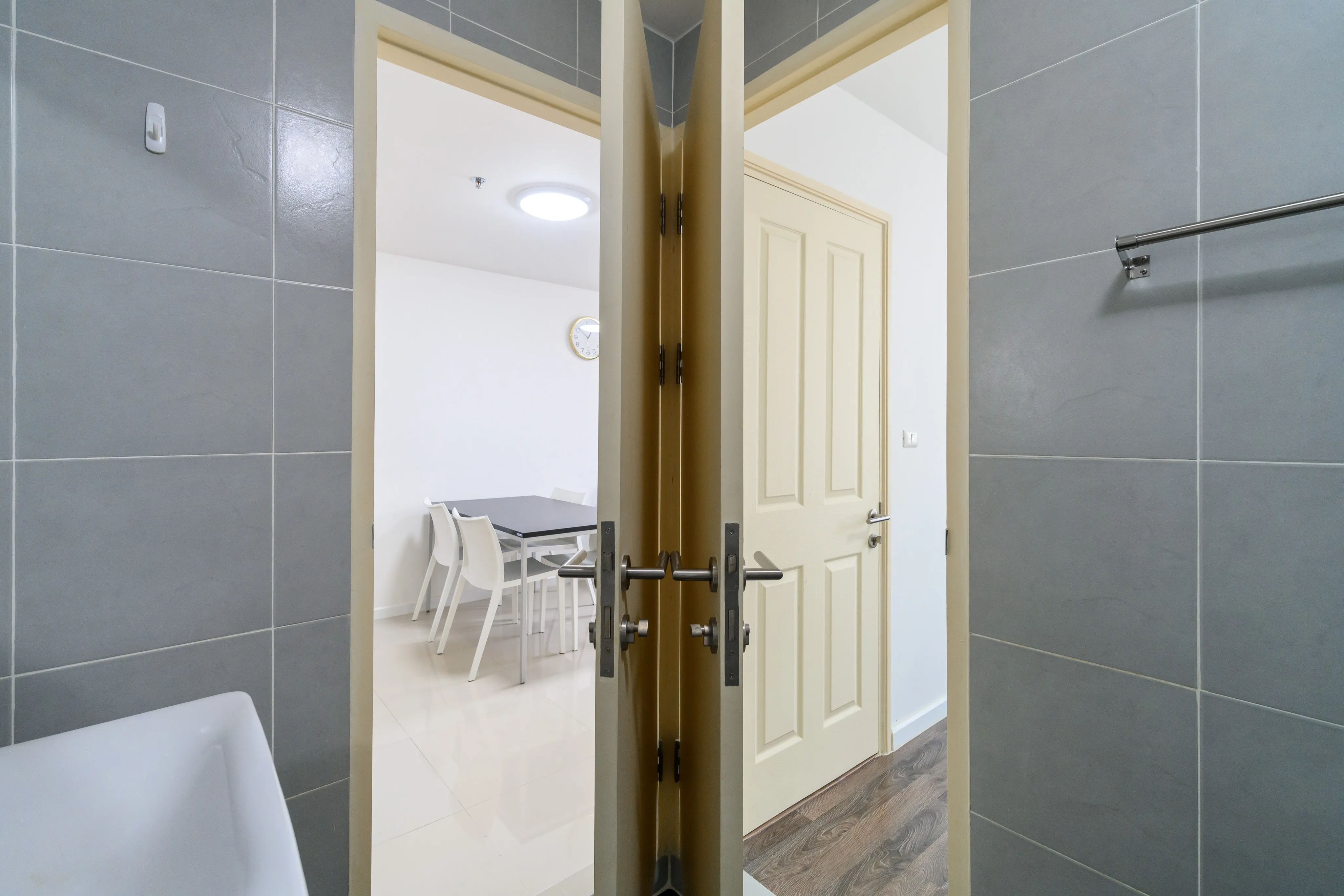 Apartment bathroom viewed through an open door with a glass shower partition