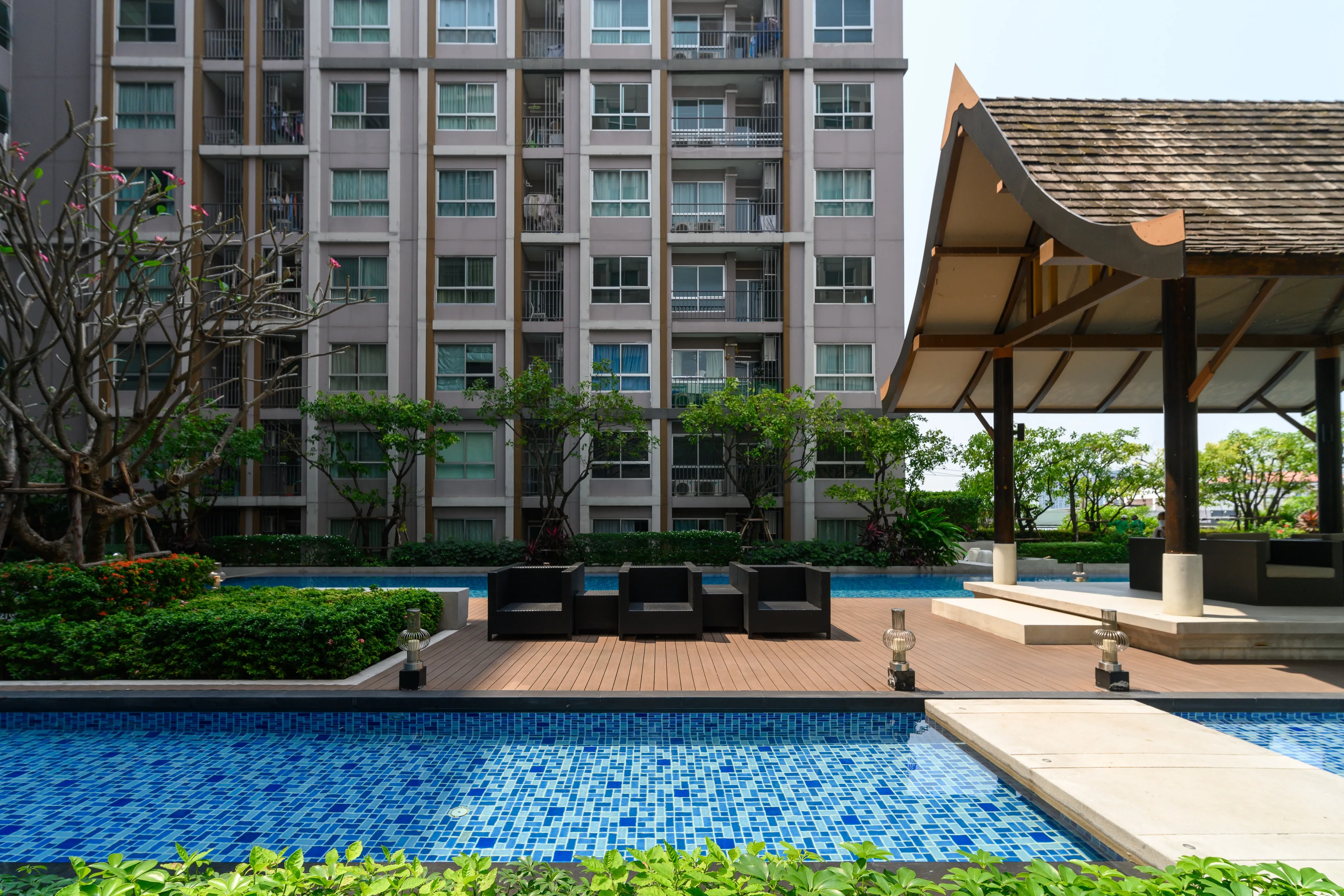 Residential swimming pool and shaded pavilion surrounded by apartment buildings
