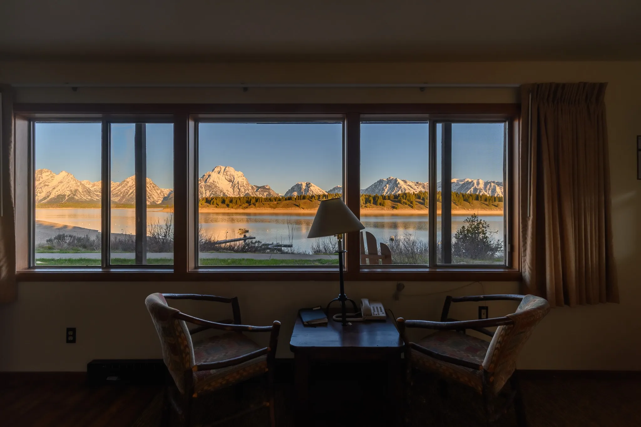 Lodge interior framing a mountain range through a wide window