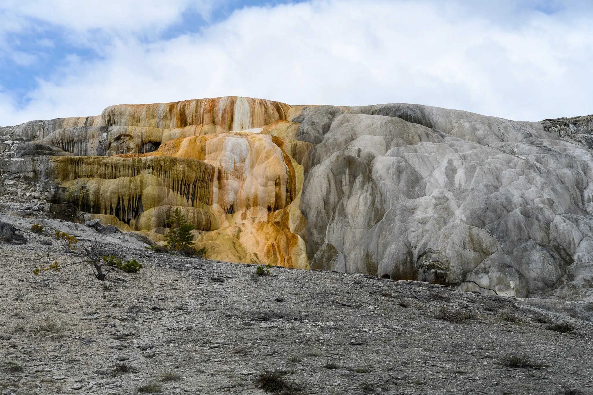 Pale mineral terraces rising through a hazy geothermal landscape