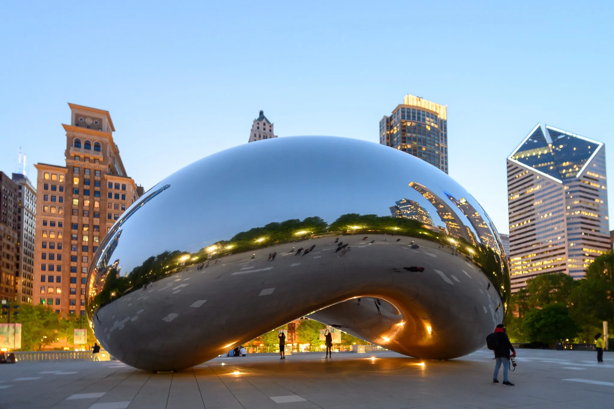 Reflective Cloud Gate sculpture surrounded by Chicago skyscrapers