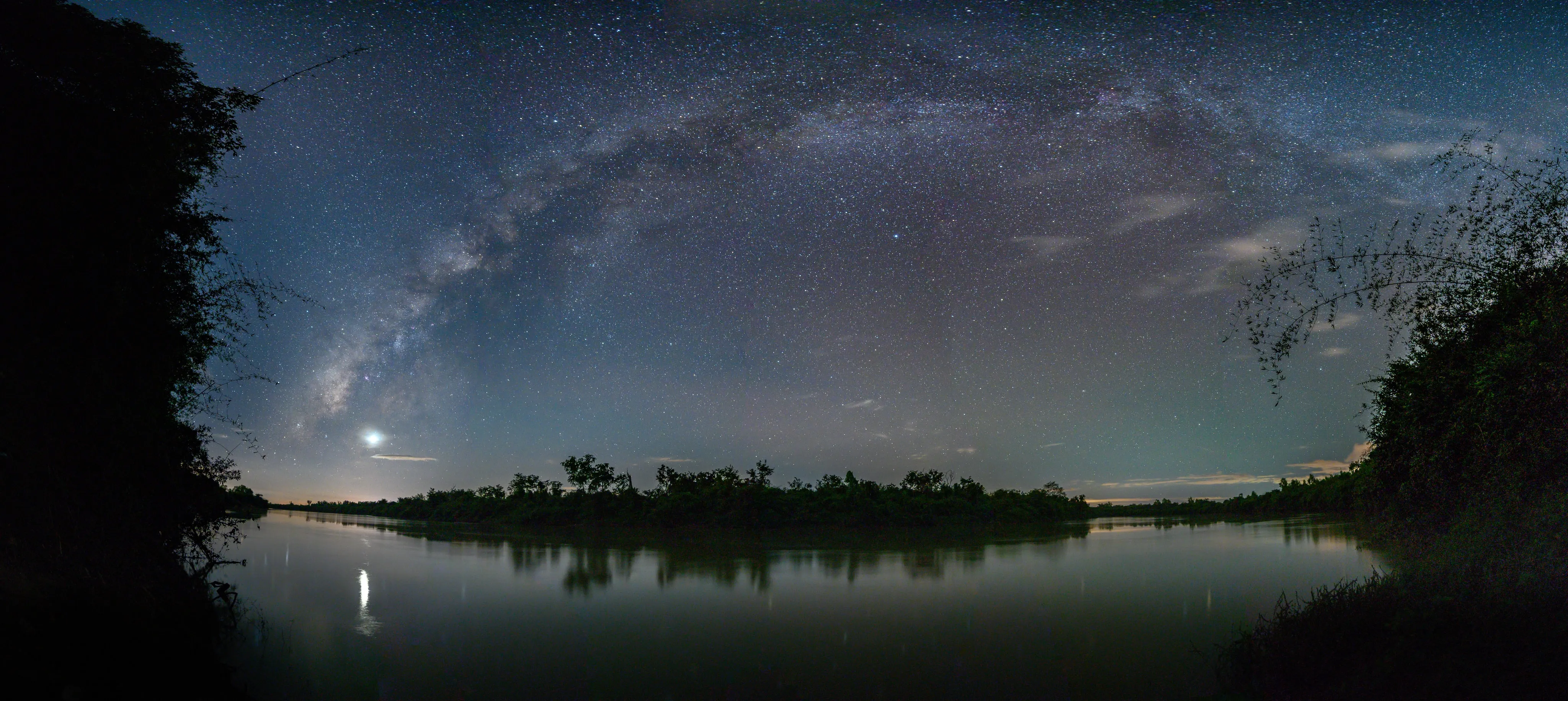 A wide sweep of the Milky Way reflected in a lake
