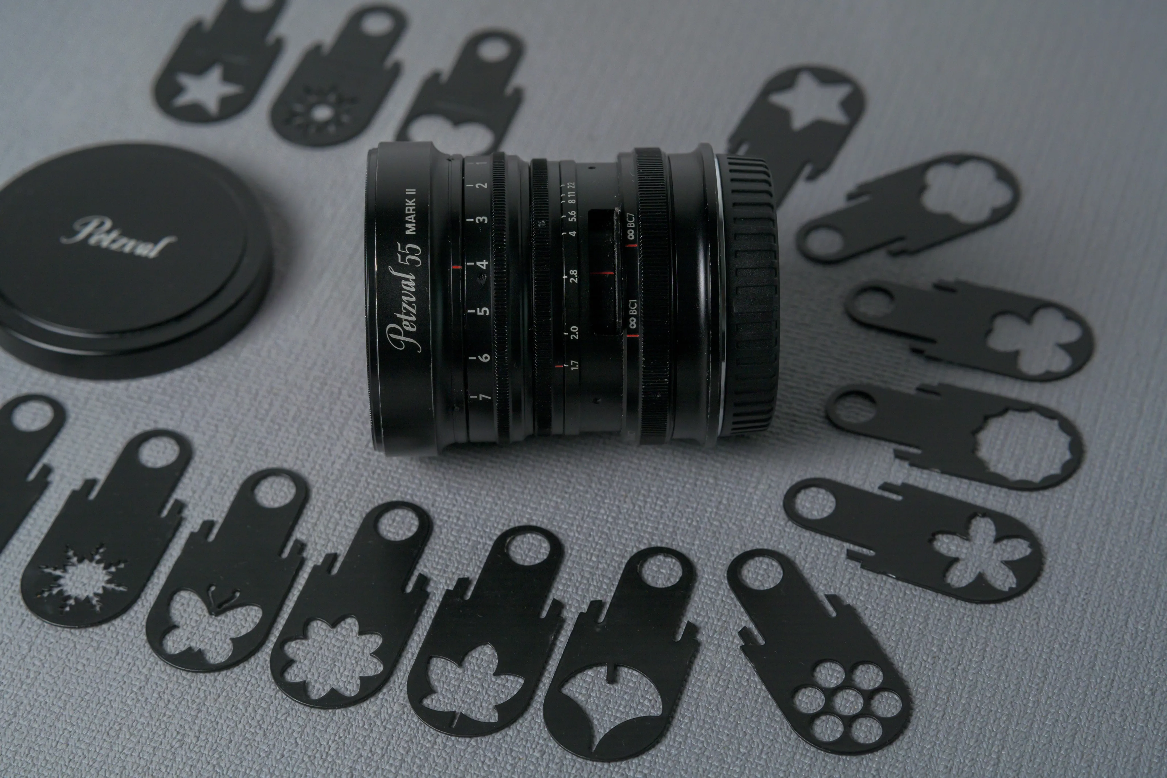 A lens displayed beside a set of decorative aperture discs
