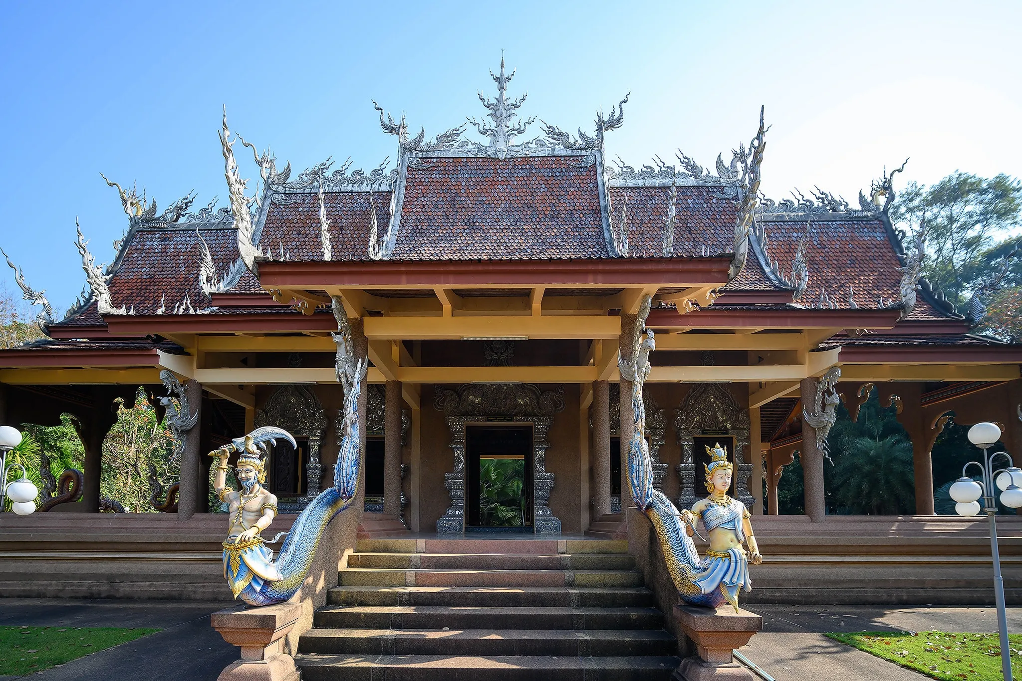 An ornate Thai temple entrance framed by guardian statues