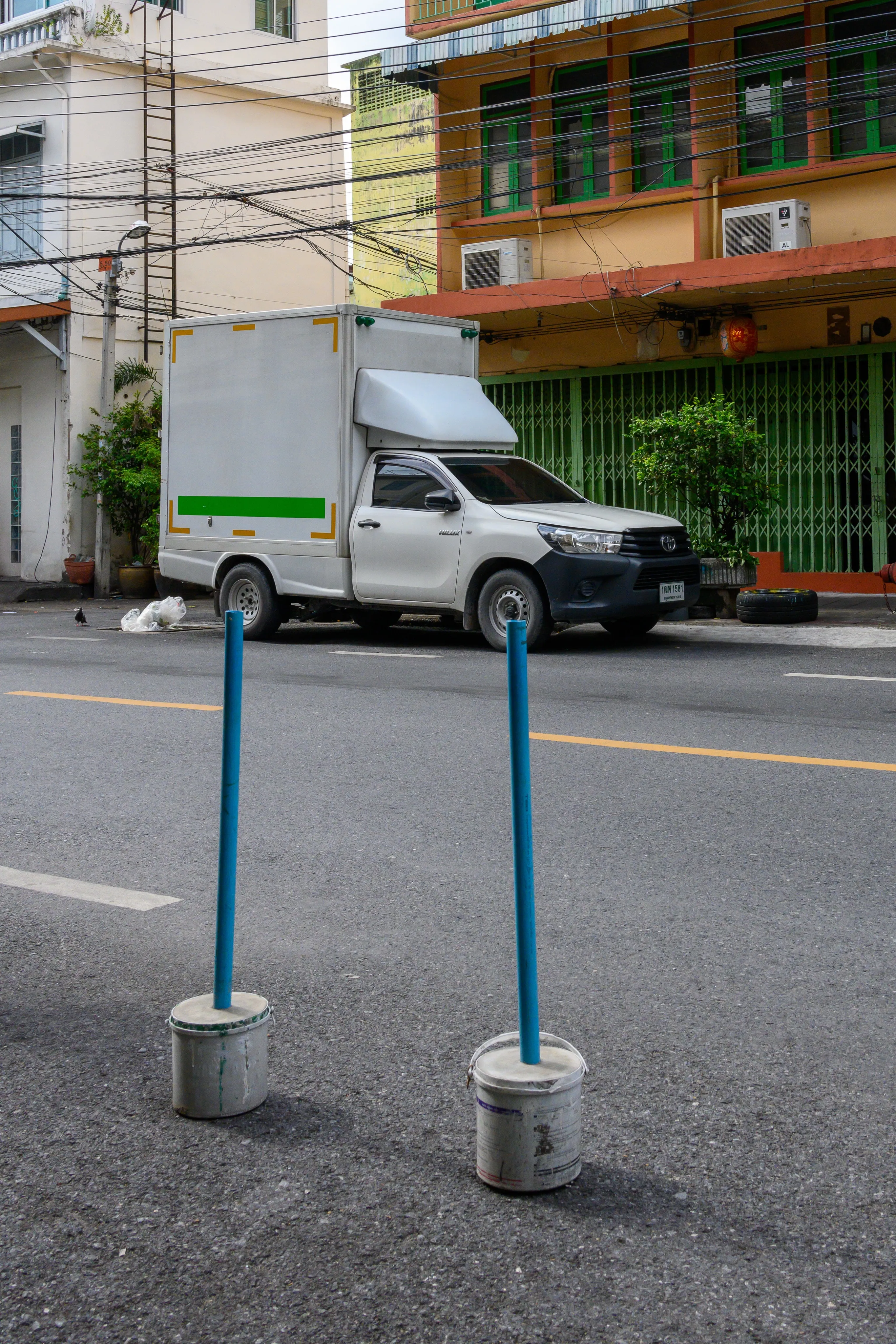 White delivery van parked across from colorful urban shop houses