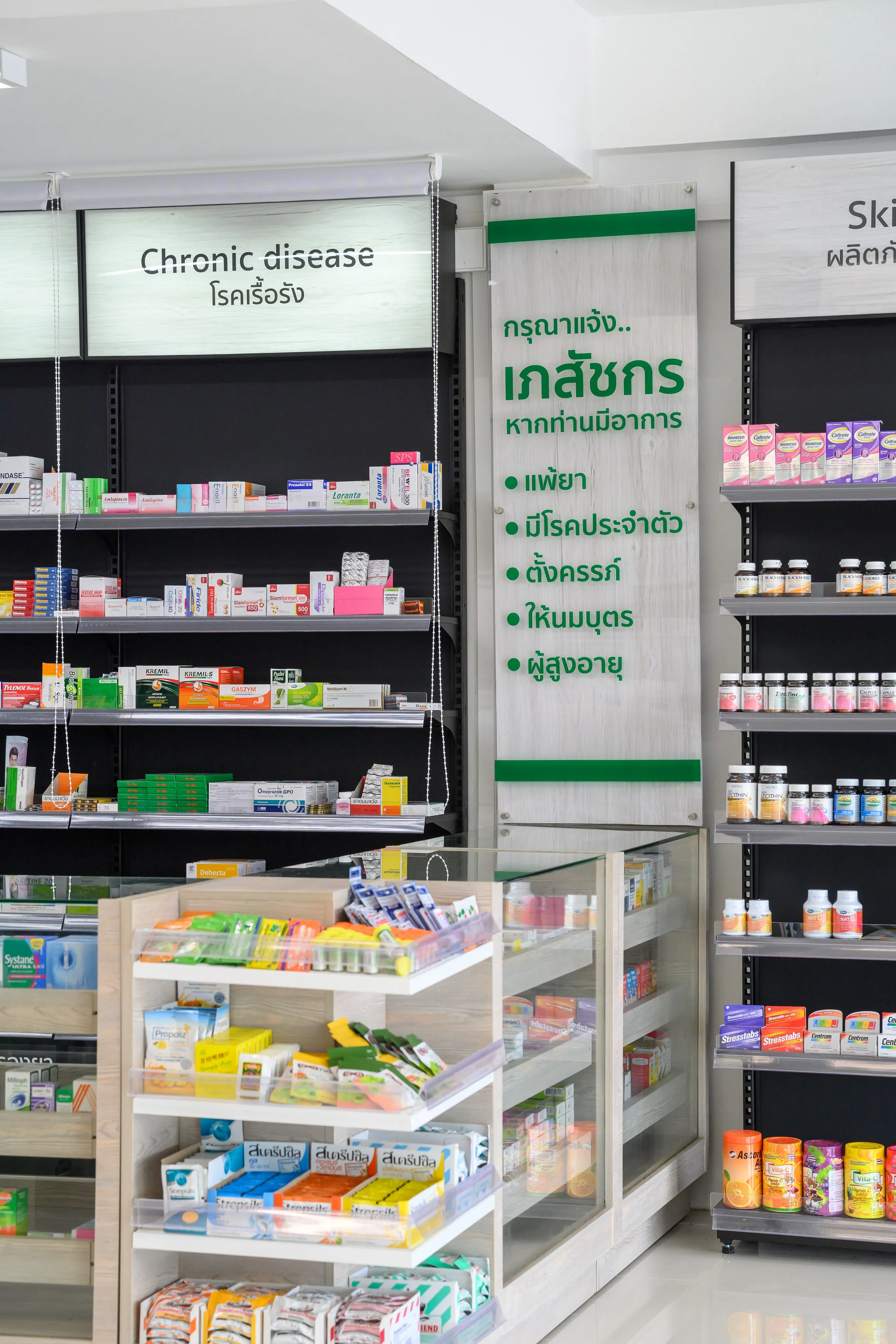 Pharmacy shelving beneath bilingual service signs