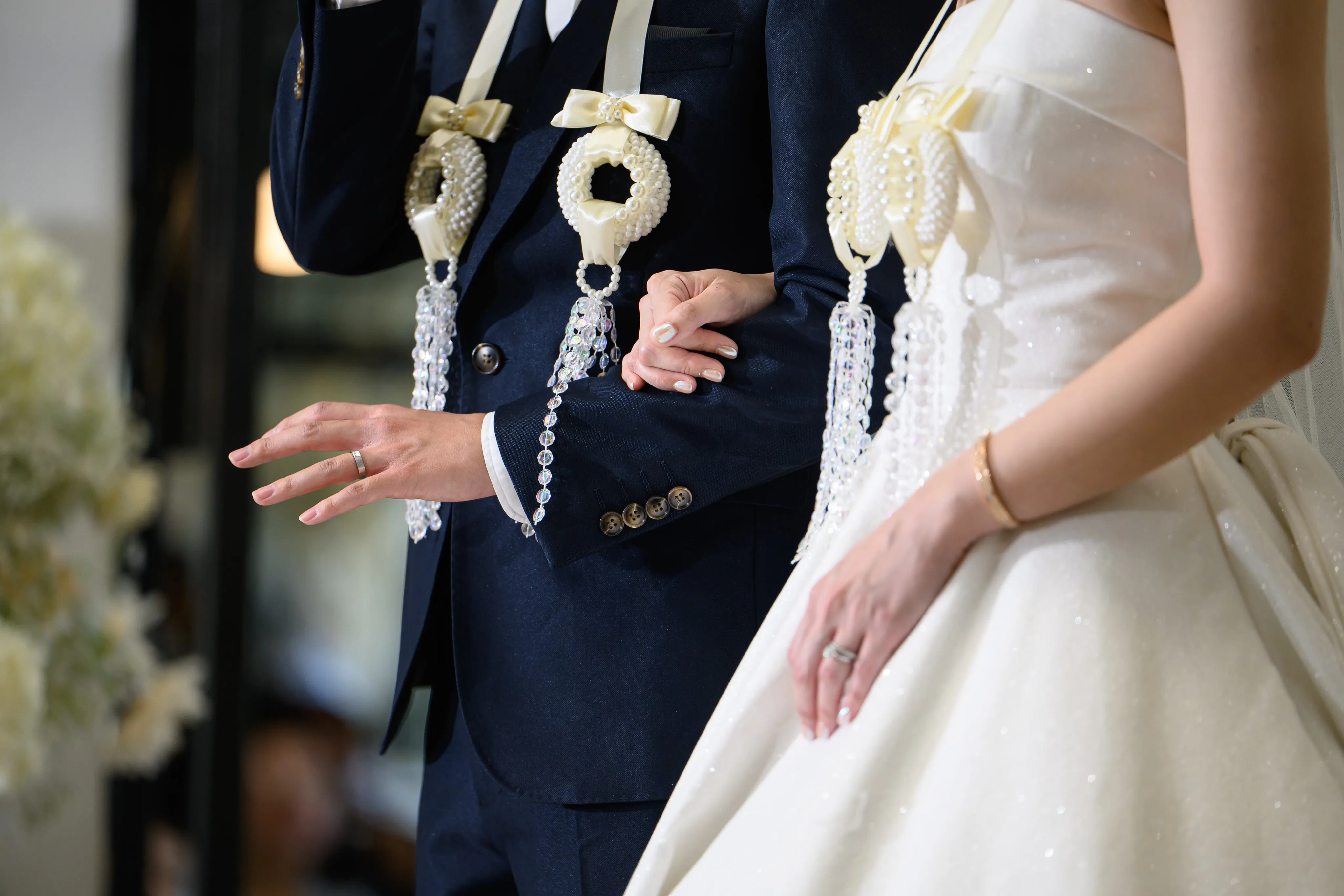 Wedding garlands and the hands of a bride and groom
