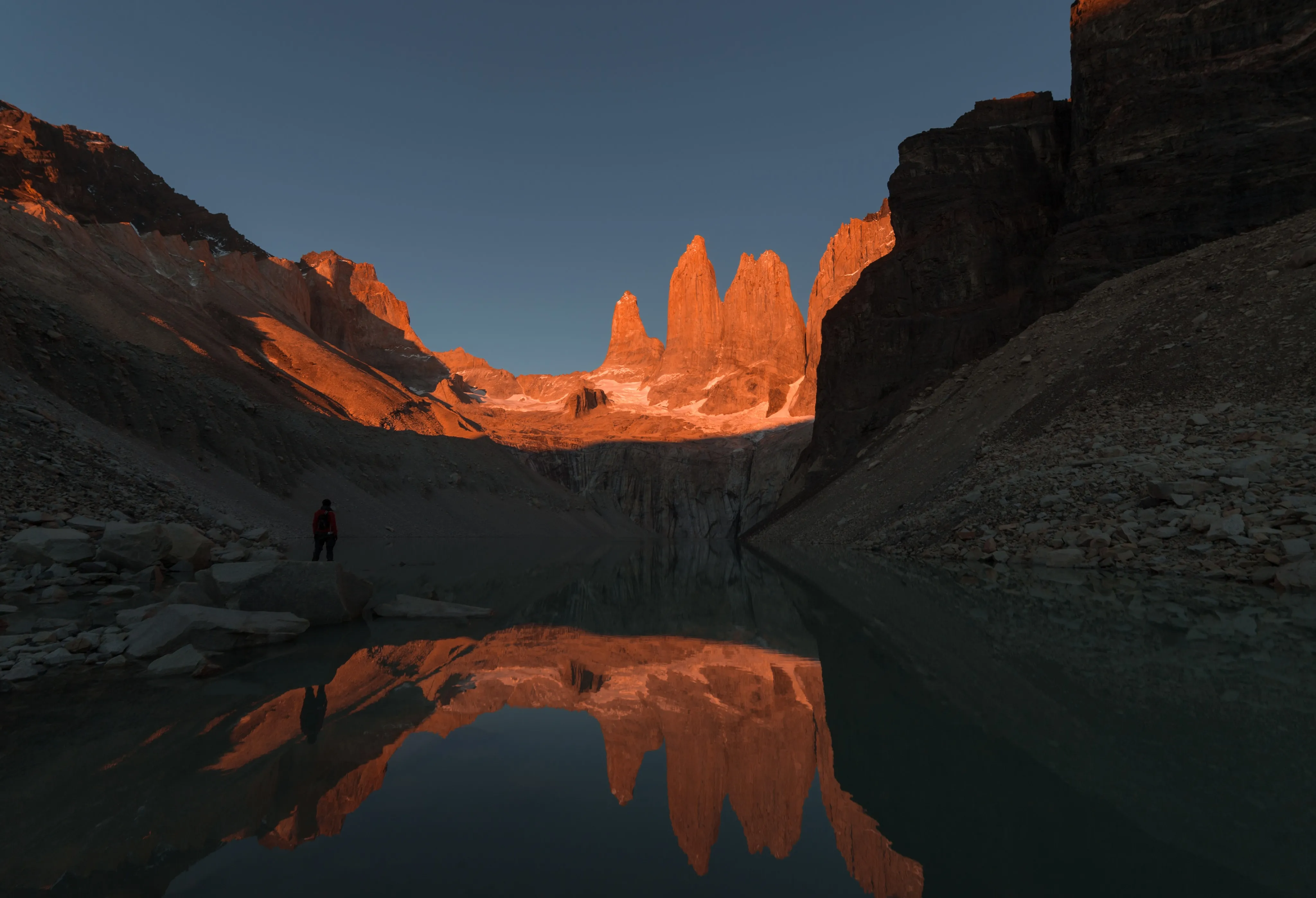 Granite mountain towers reflected in a still lake at sunset