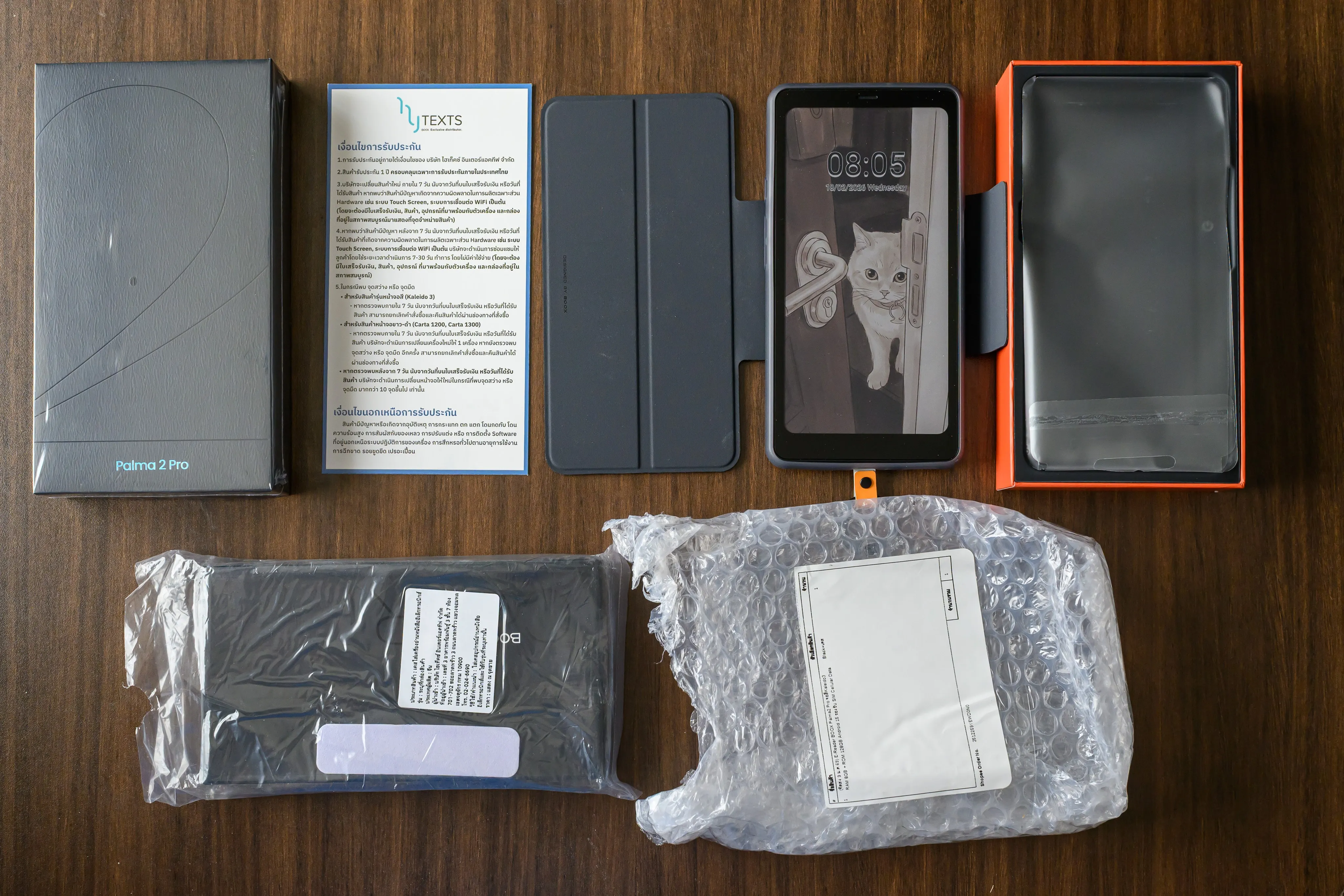 Flat lay of boxed consumer electronics and accessories on a wood table