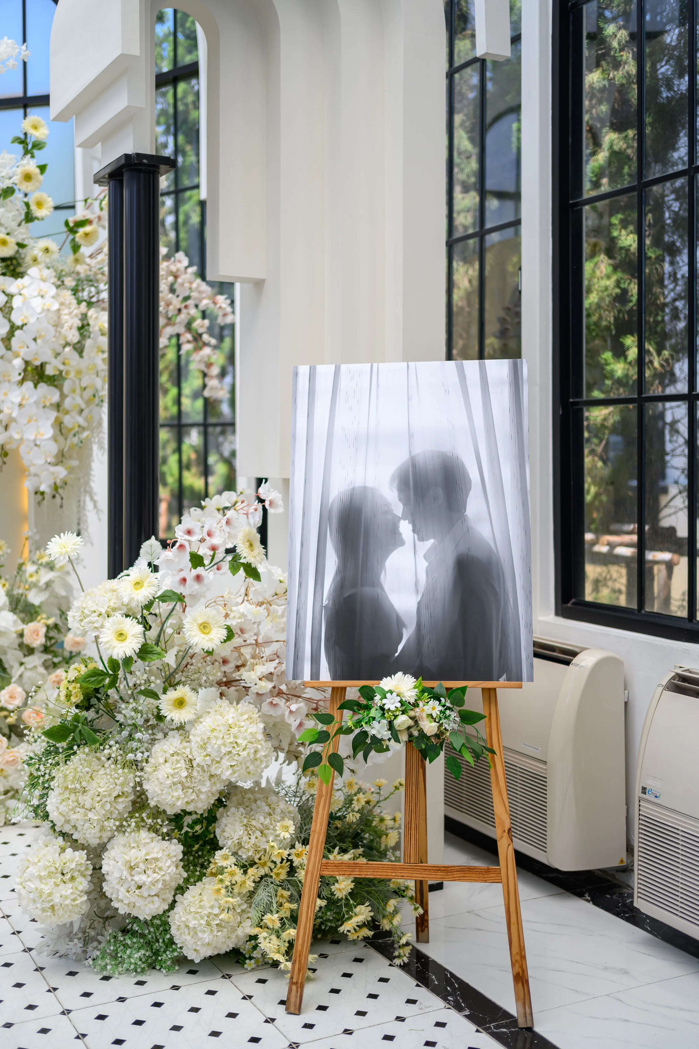 A framed silhouette of a couple beside wedding flowers