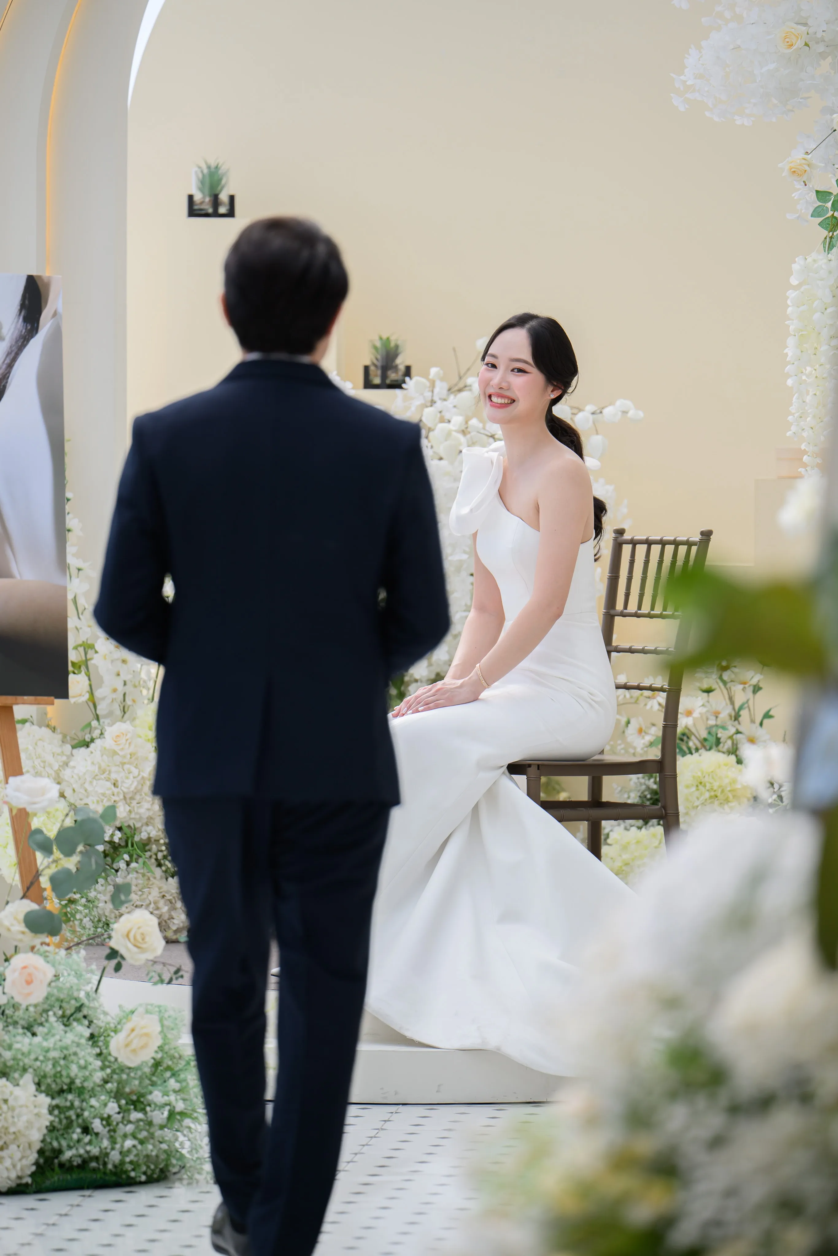 A groom approaching a seated bride in a bright room