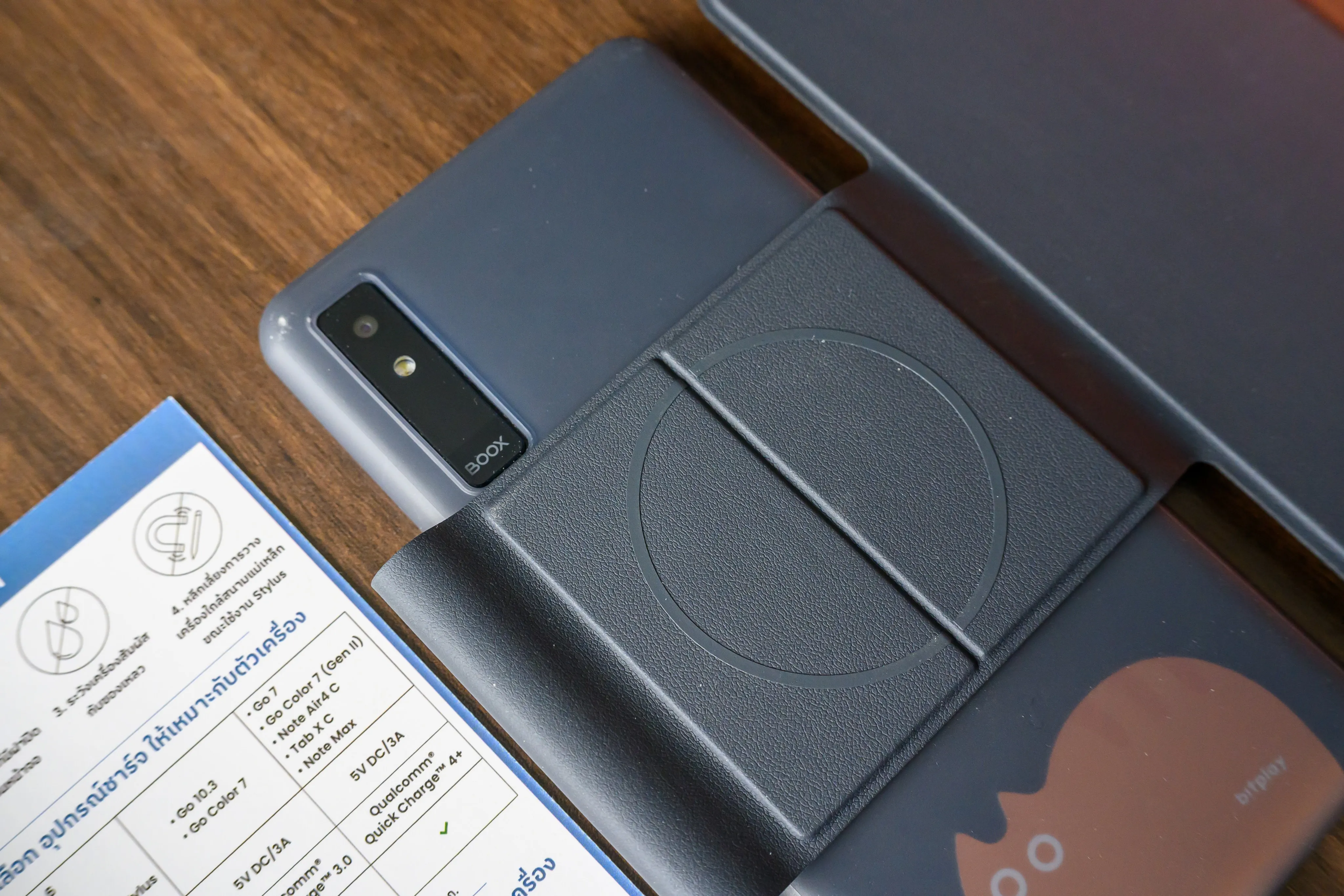 Close-up of a dark phone case and accessories on a wood surface