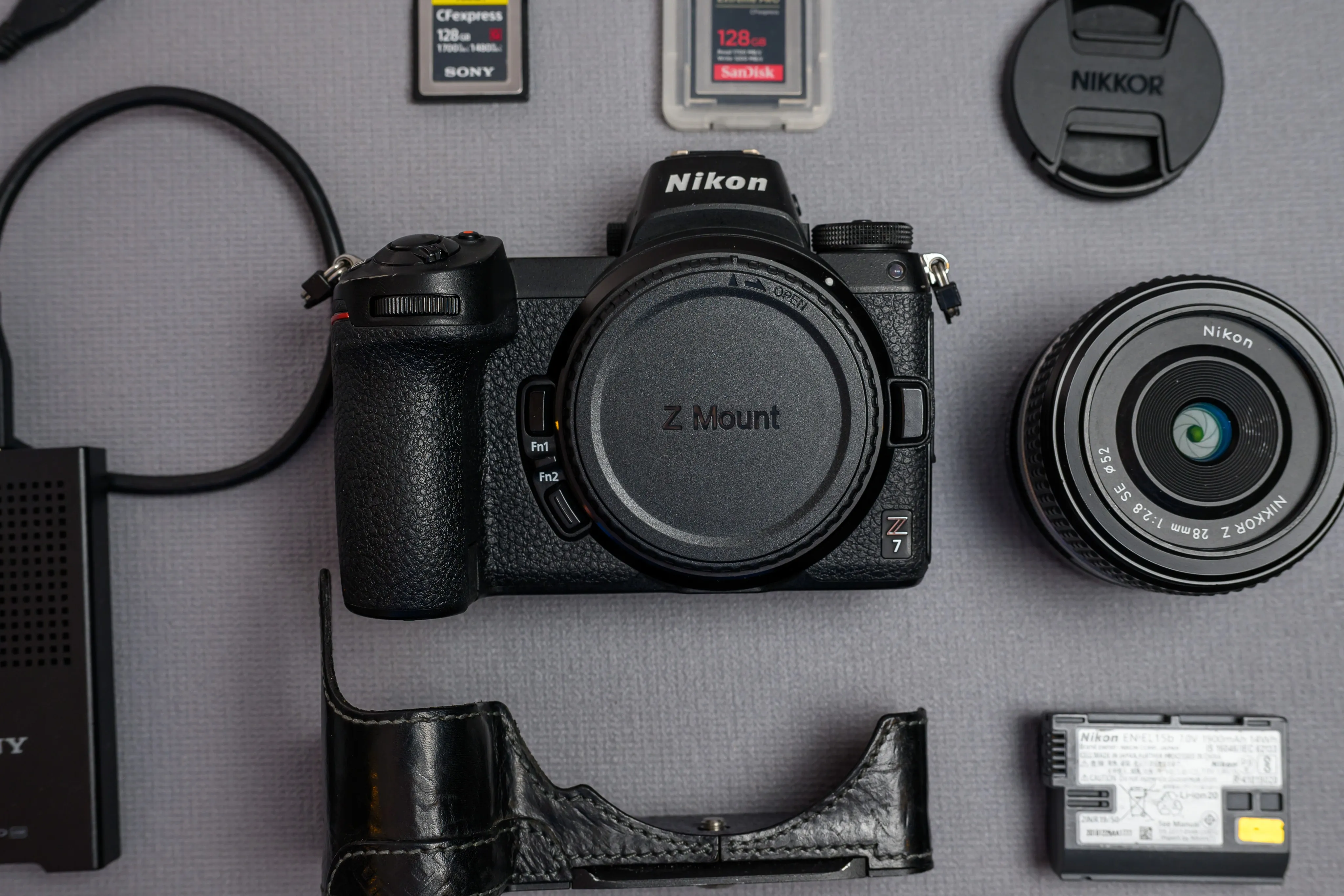Nikon camera, lens, battery, and accessories arranged in a product flat lay