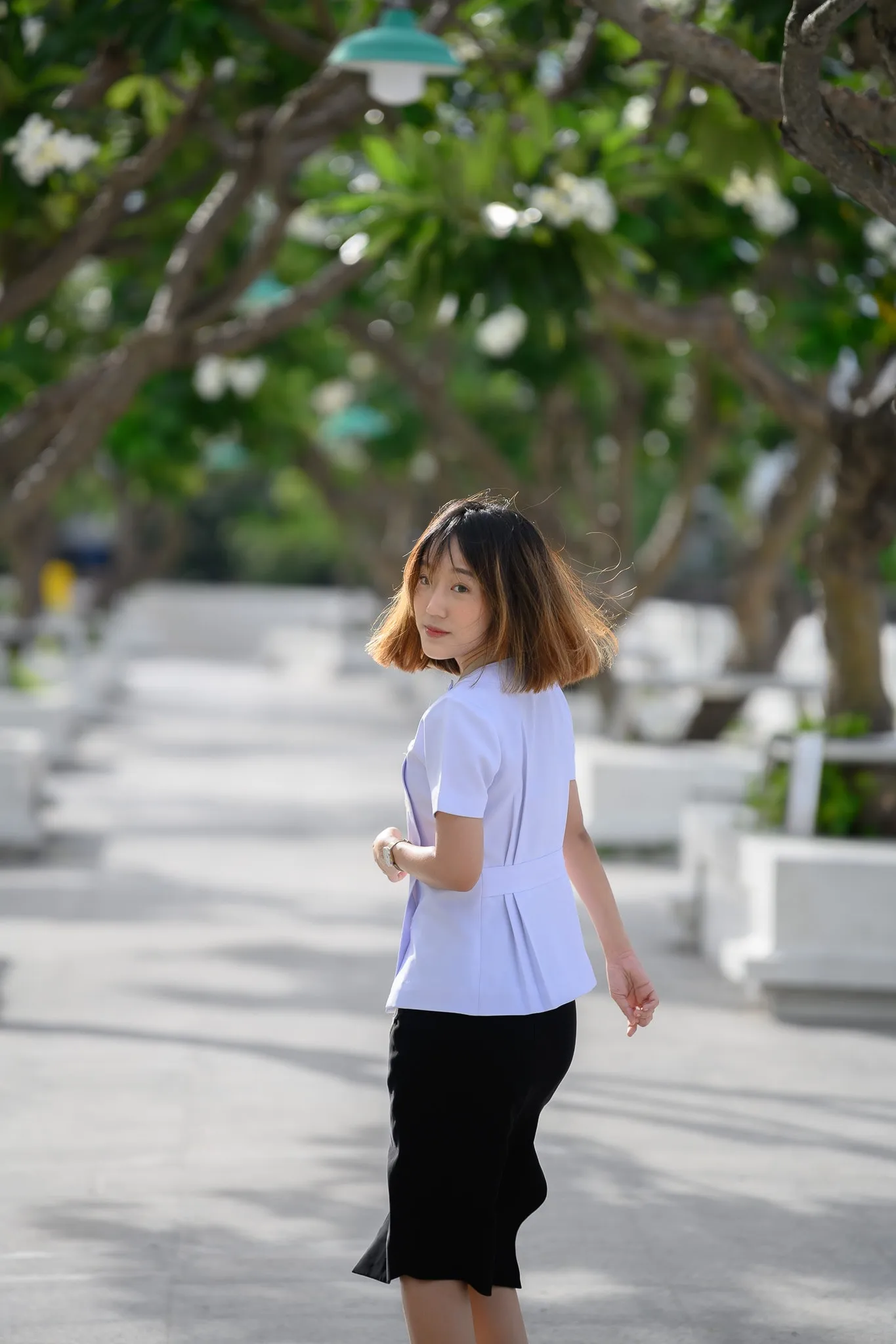 Woman walking along a bright riverside promenade