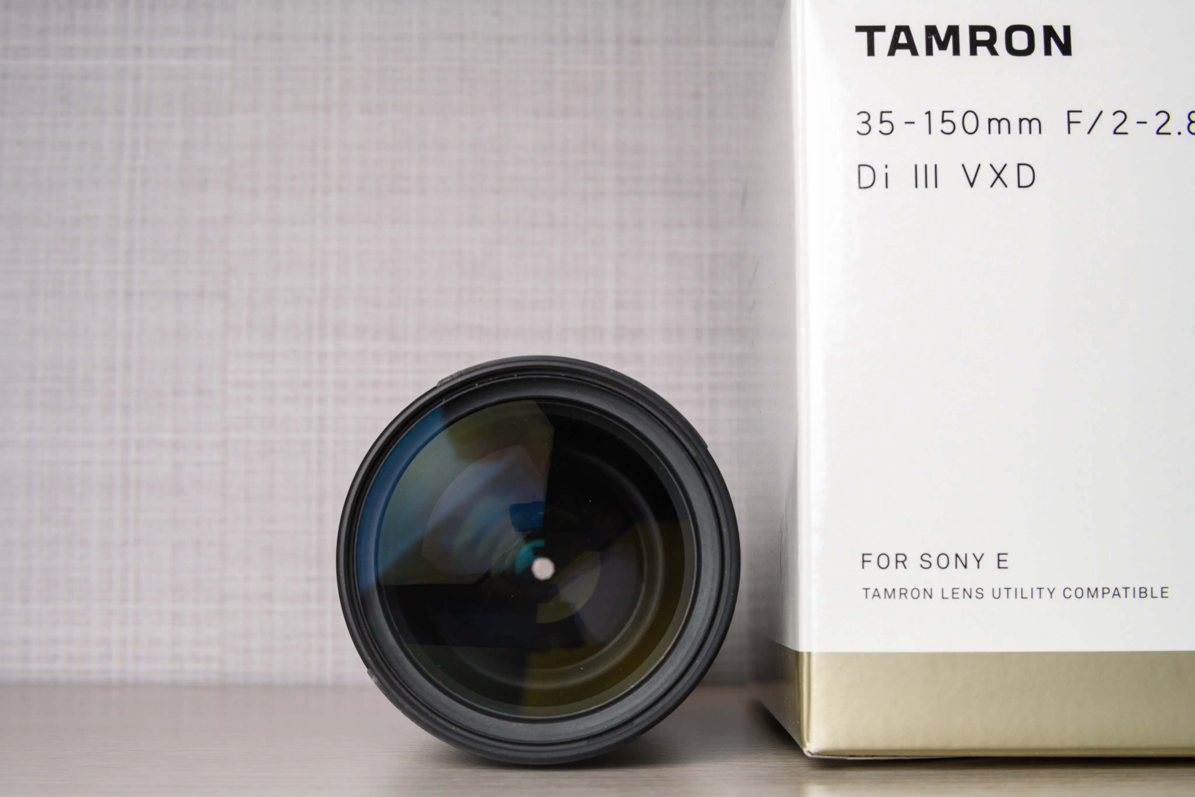 Tamron telephoto lens standing beside its product box