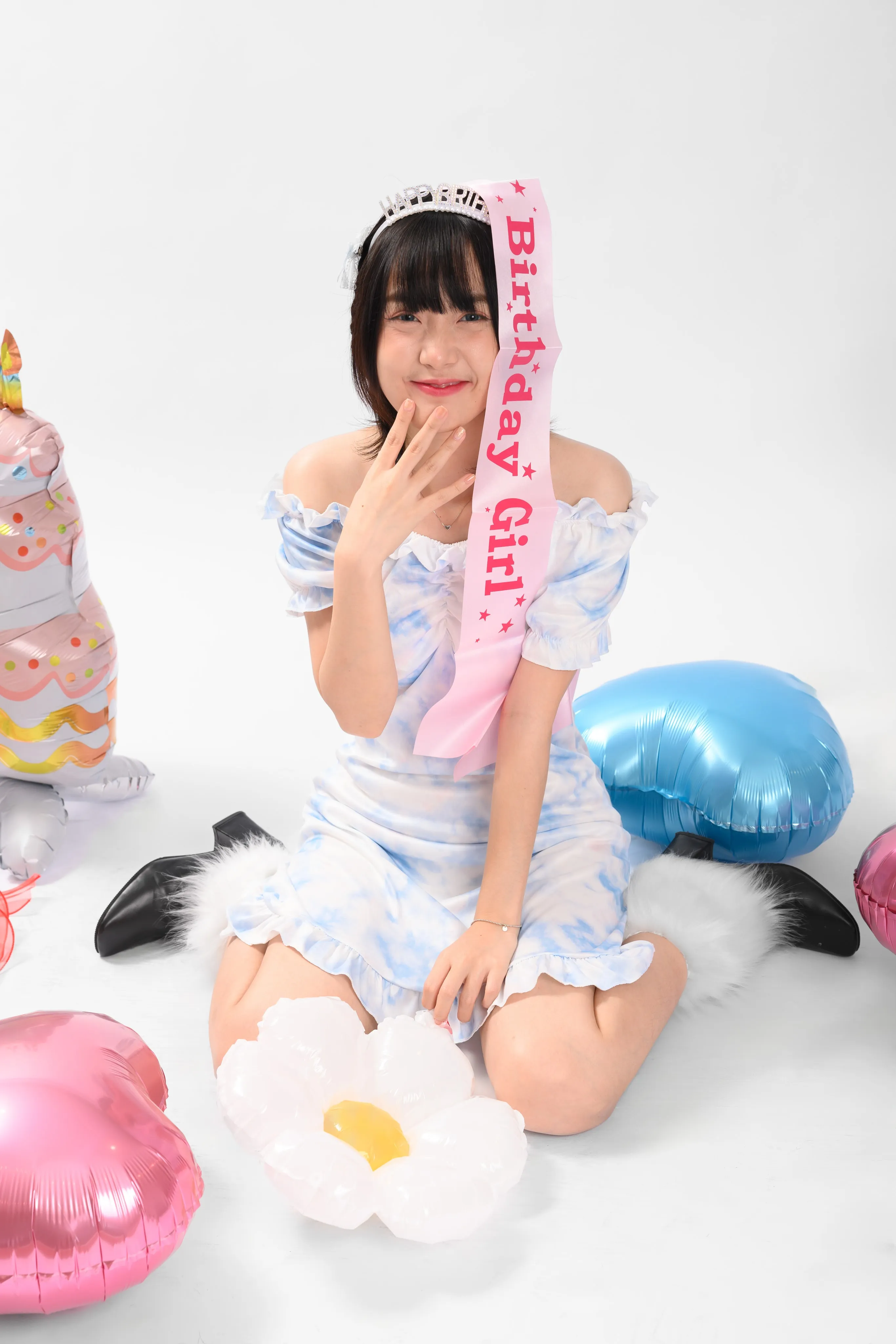 A woman celebrating her birthday with balloons and a cake