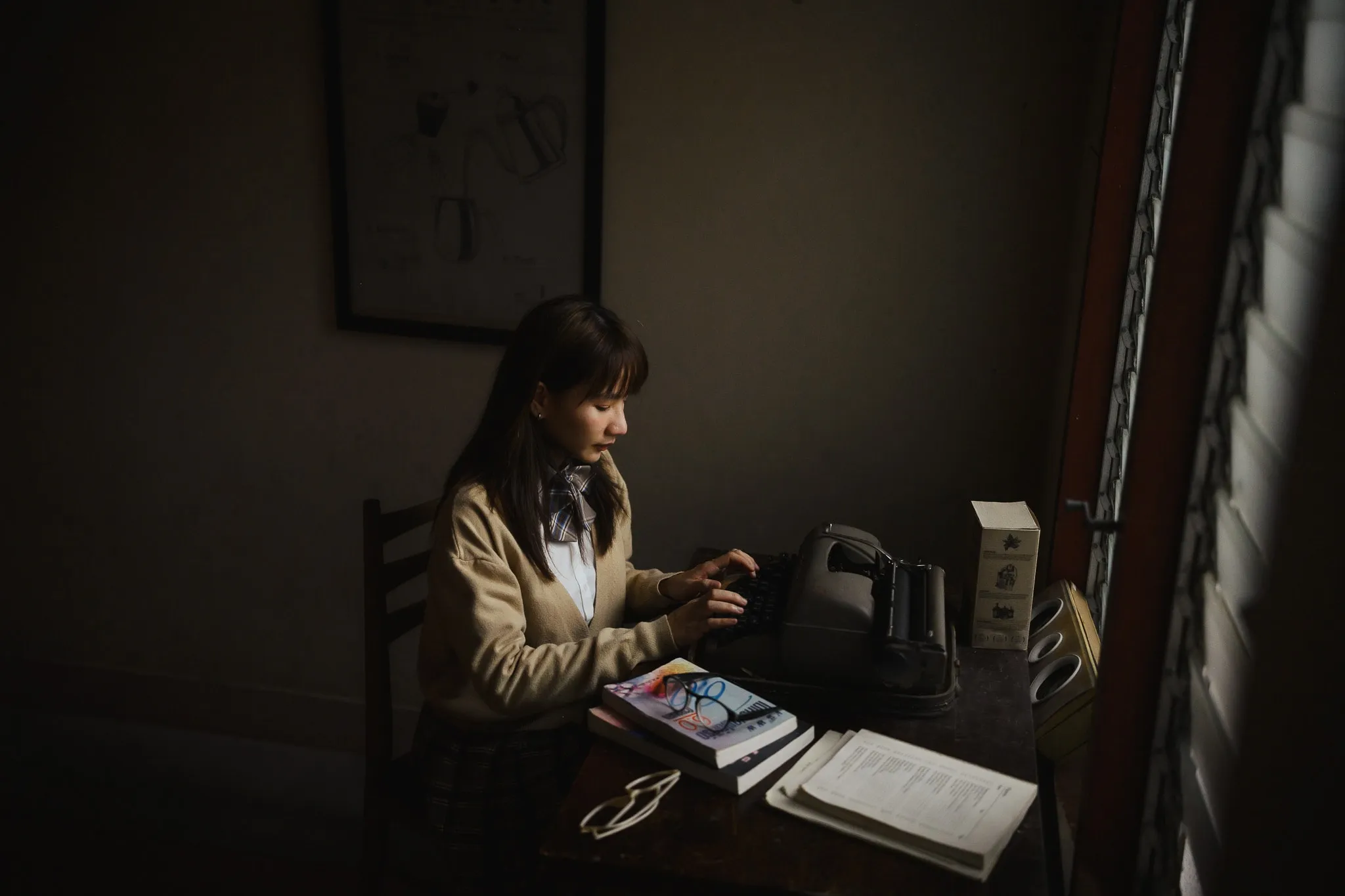Woman working at a desk in a dimly lit room