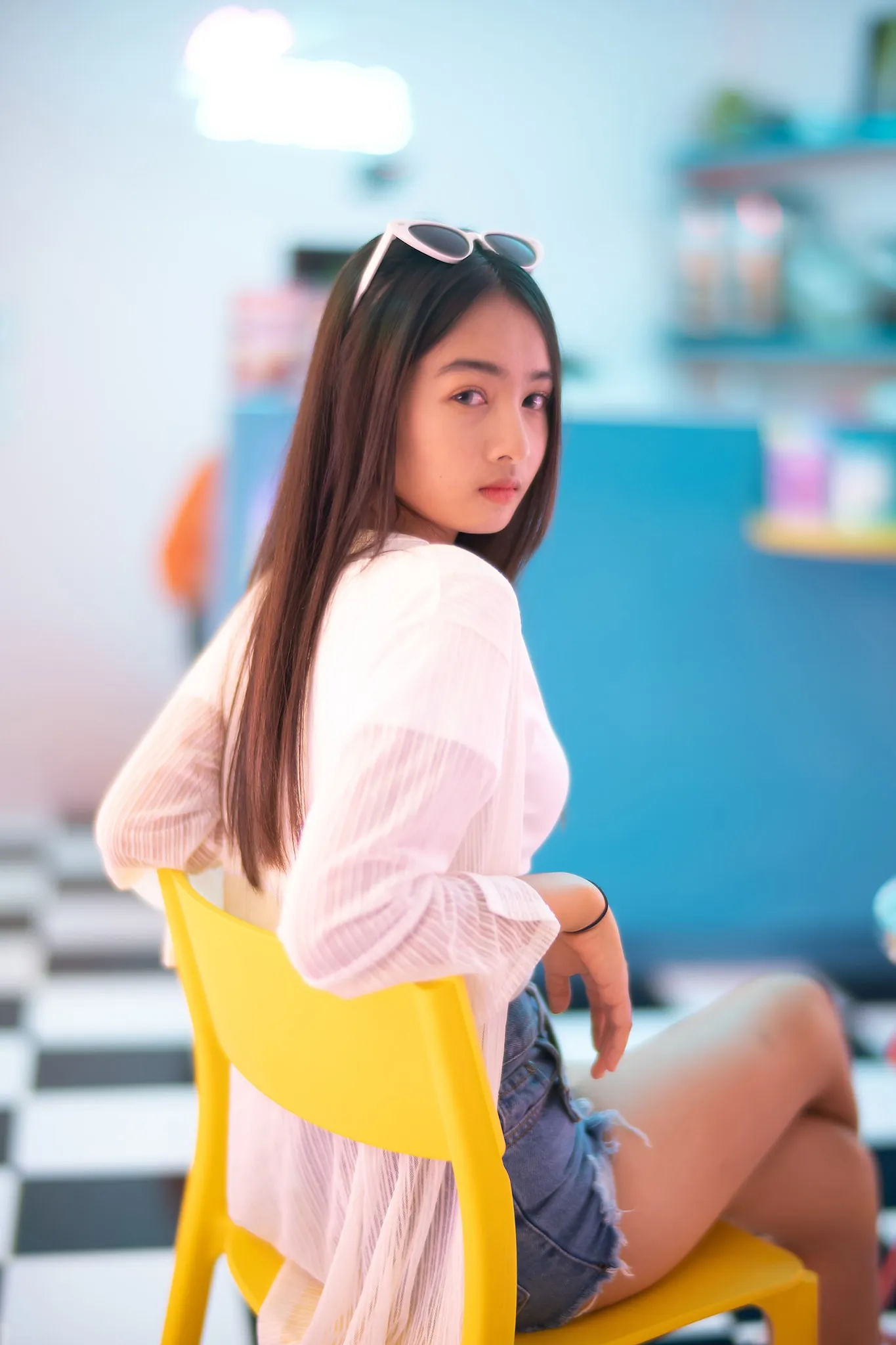 A woman in a pink blouse looking back from a yellow chair