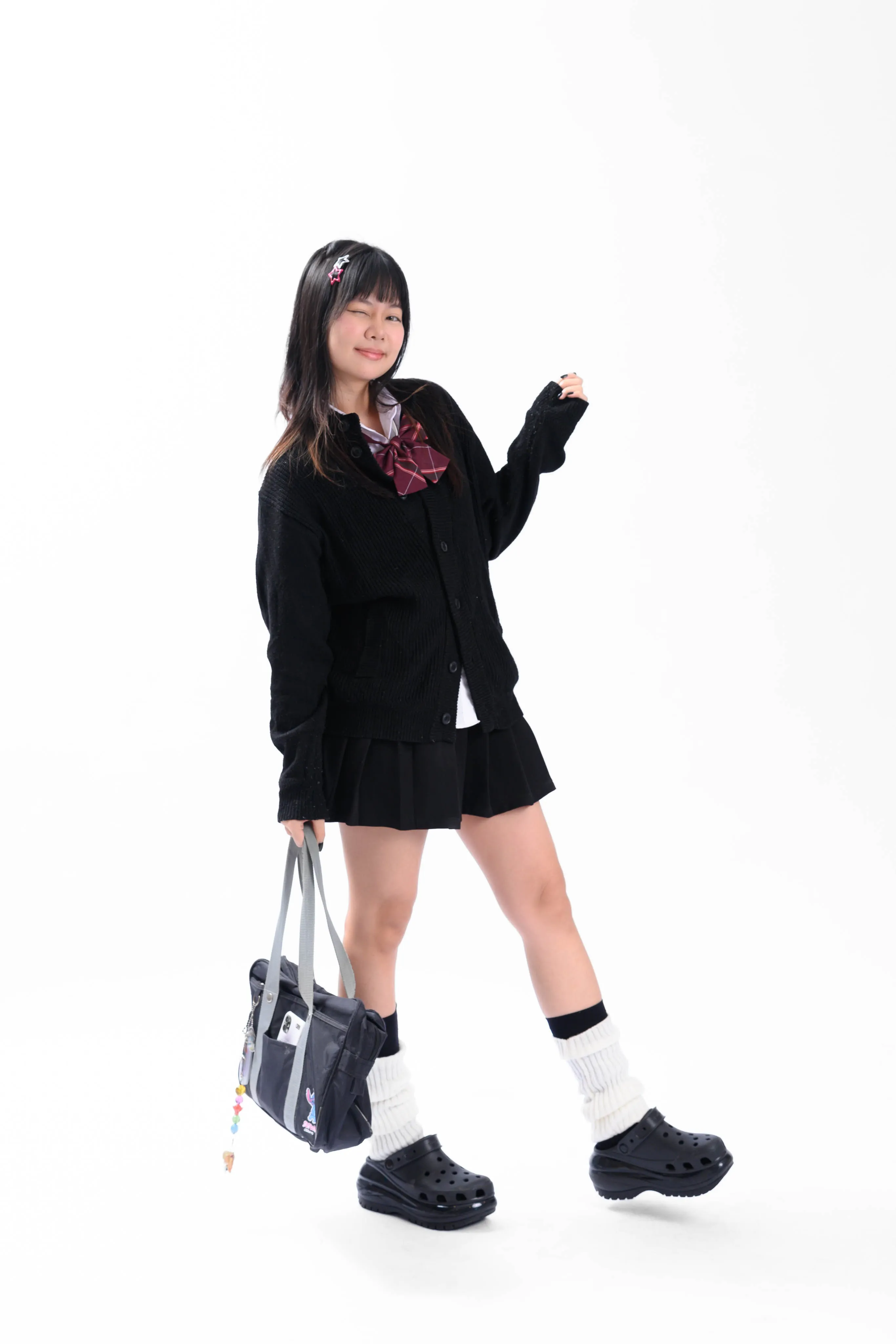 A woman in a school-style uniform posing against a plain backdrop