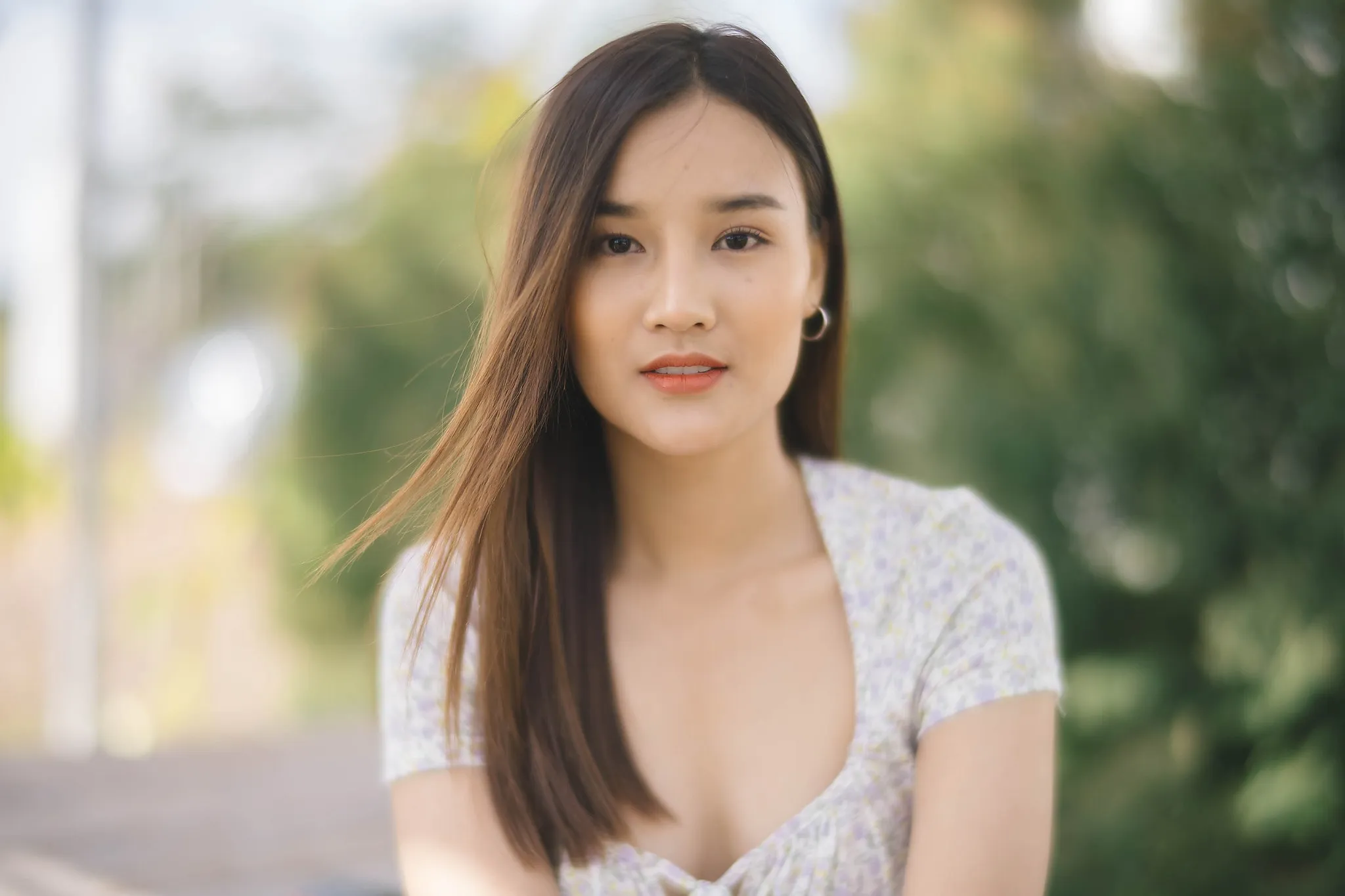 A close portrait of a woman in a white floral dress