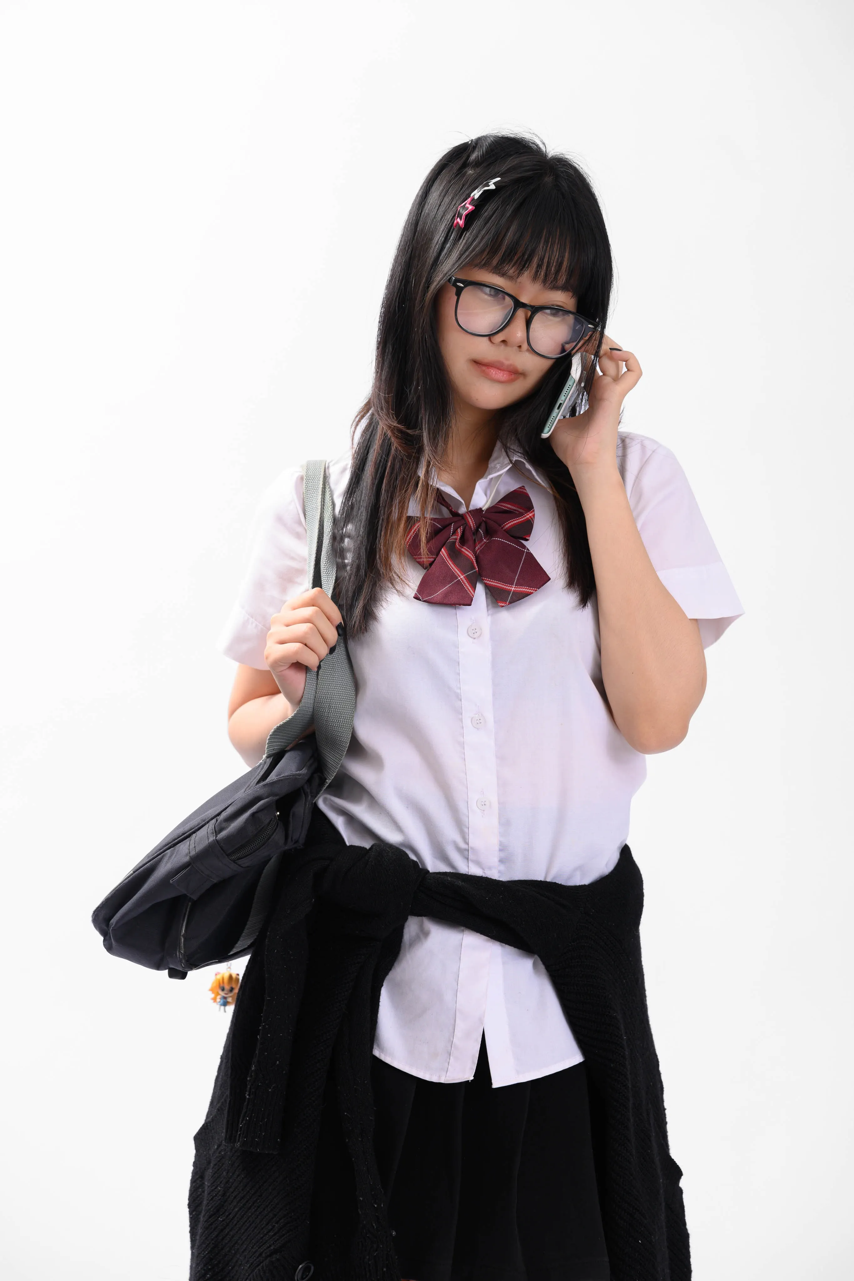 A woman in a school-style uniform holding a phone to her ear