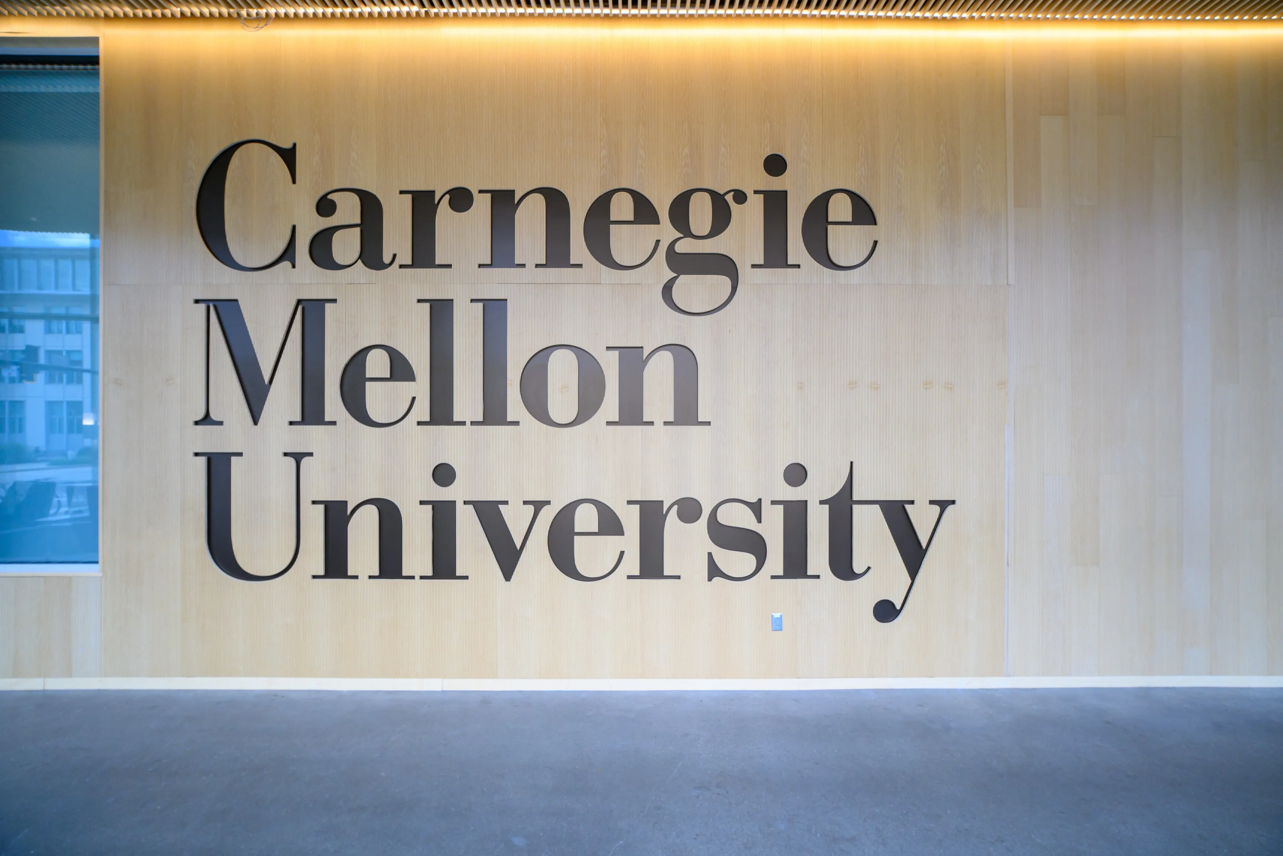 "Carnegie Mellon University" lettering on a wood-paneled wall.