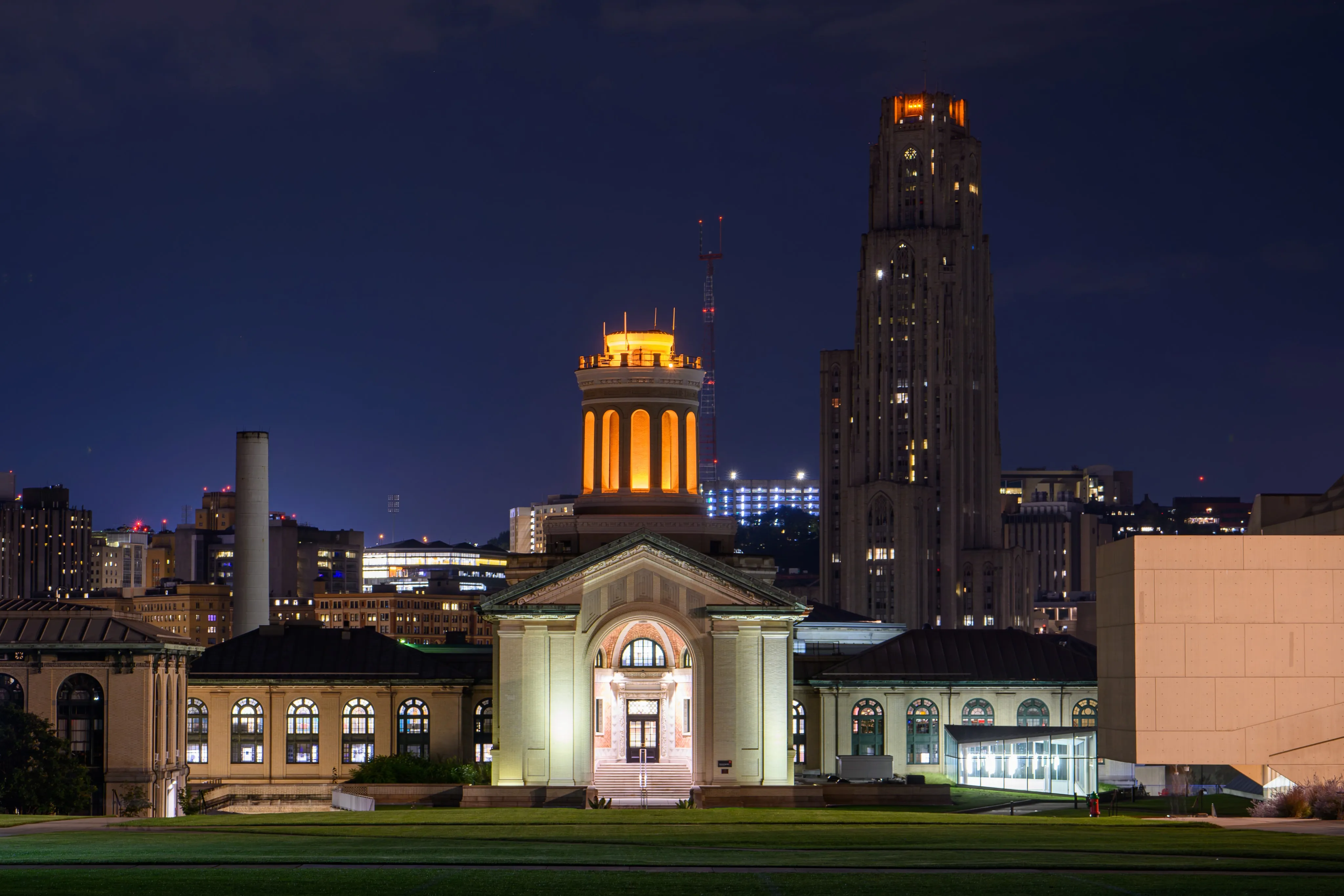 Hamerschlag Hall's illuminated dome at night, with the University of Pittsburgh's Cathedral of Learning rising behind it.