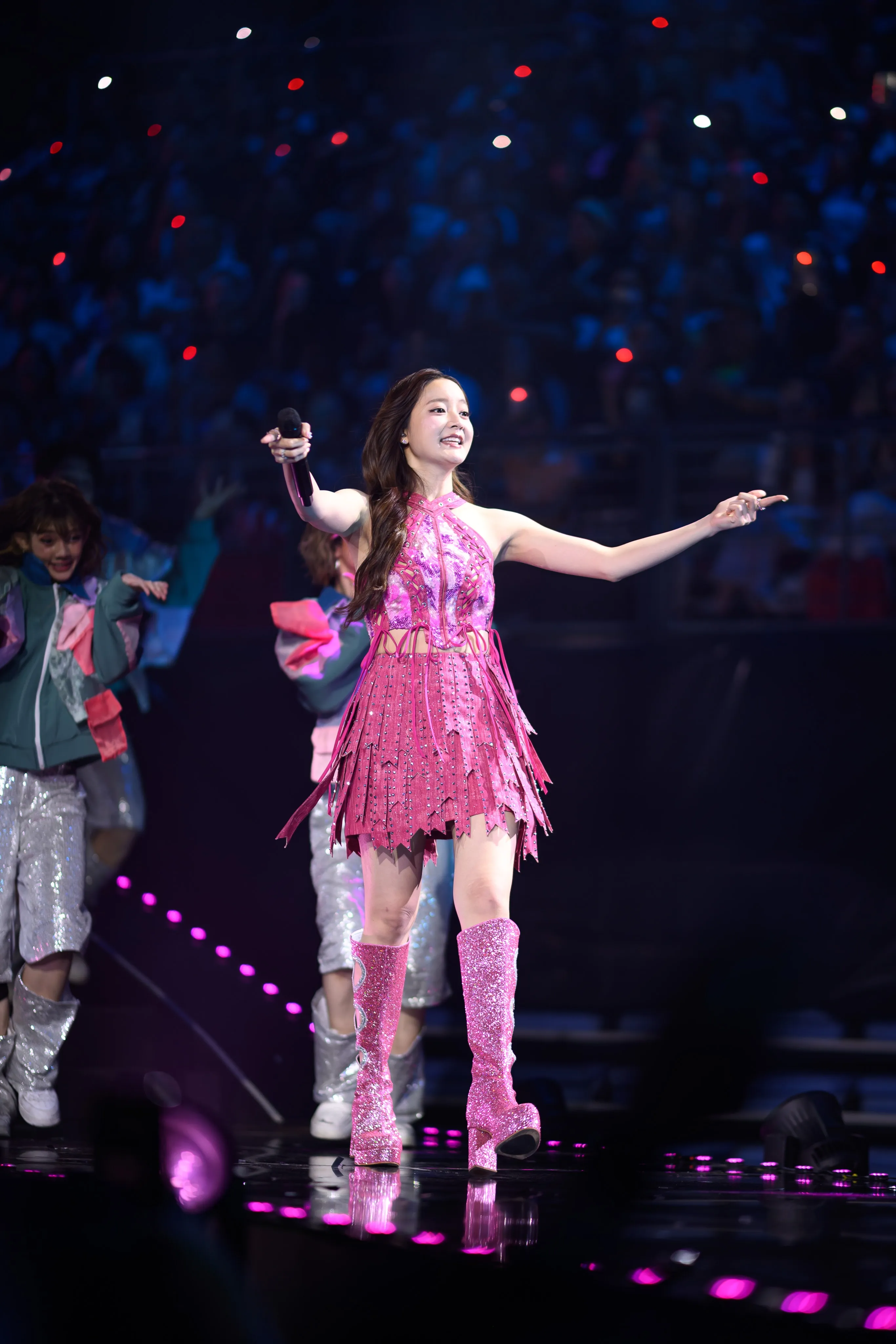 A performer gesturing to the crowd during a concert