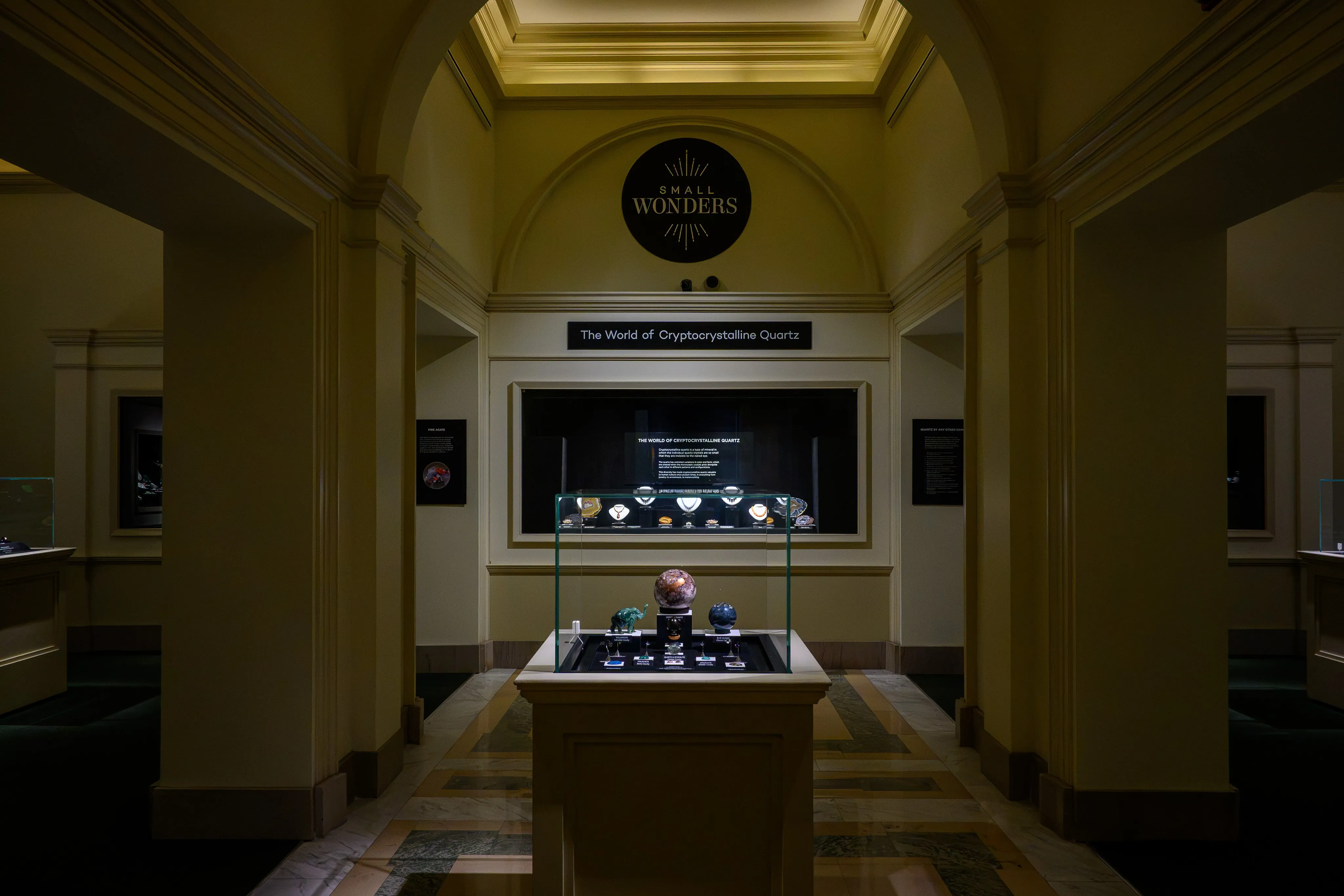 A dimly lit museum gallery entrance with a glowing exhibit sign in the distance.