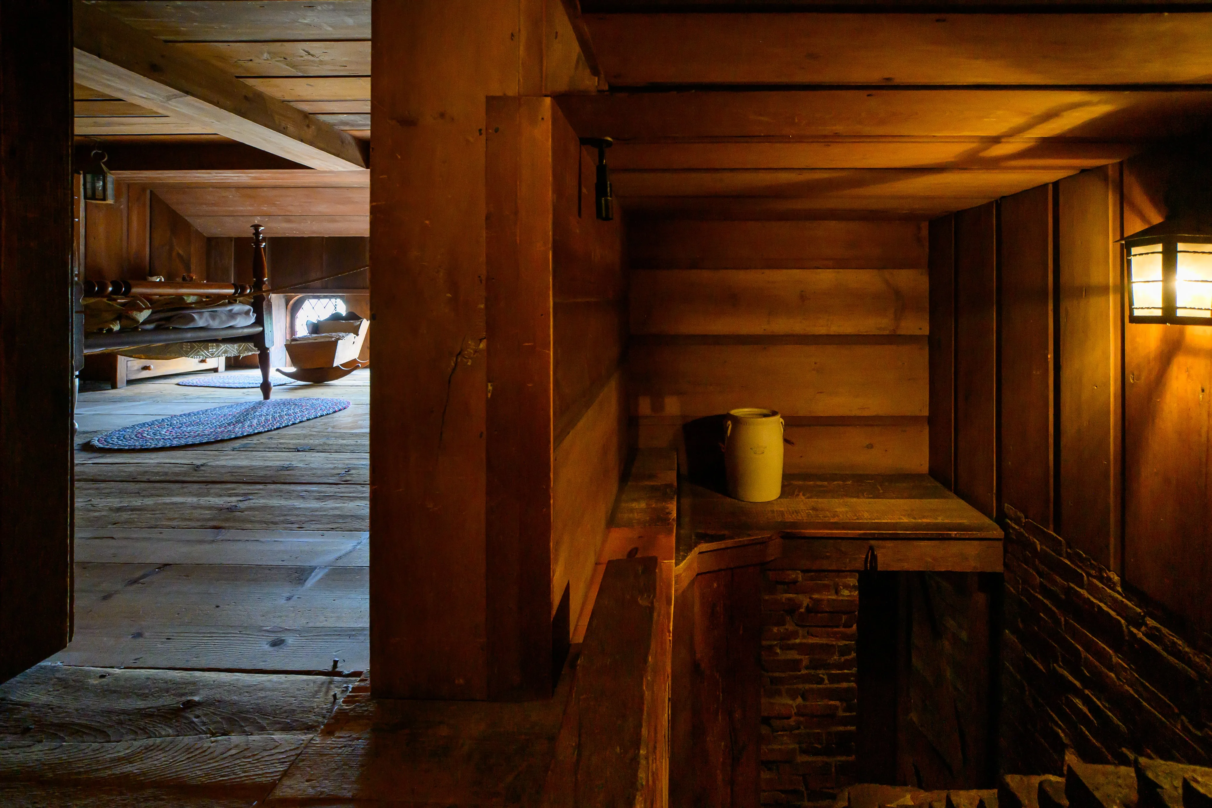 A colonial-style room with a four-poster bed and cradle, part of the Cathedral of Learning's Nationality Rooms.
