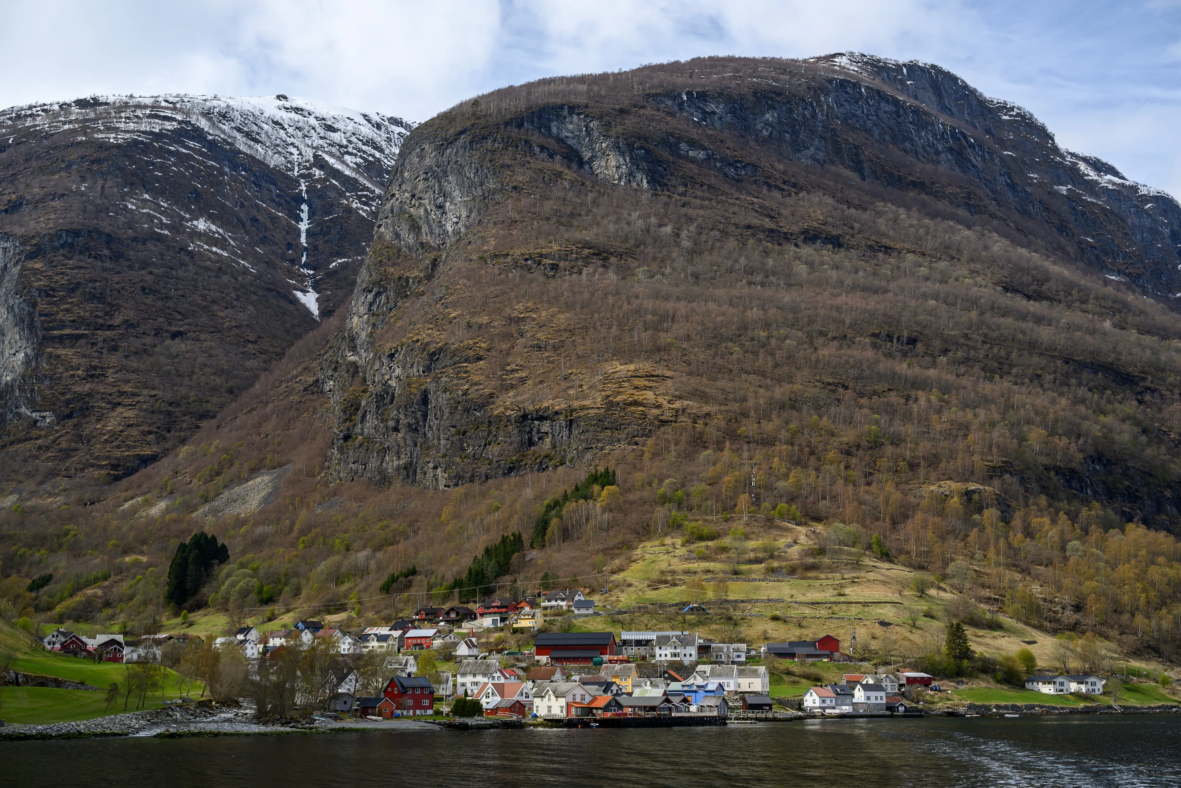 A village below snow-streaked mountain slopes