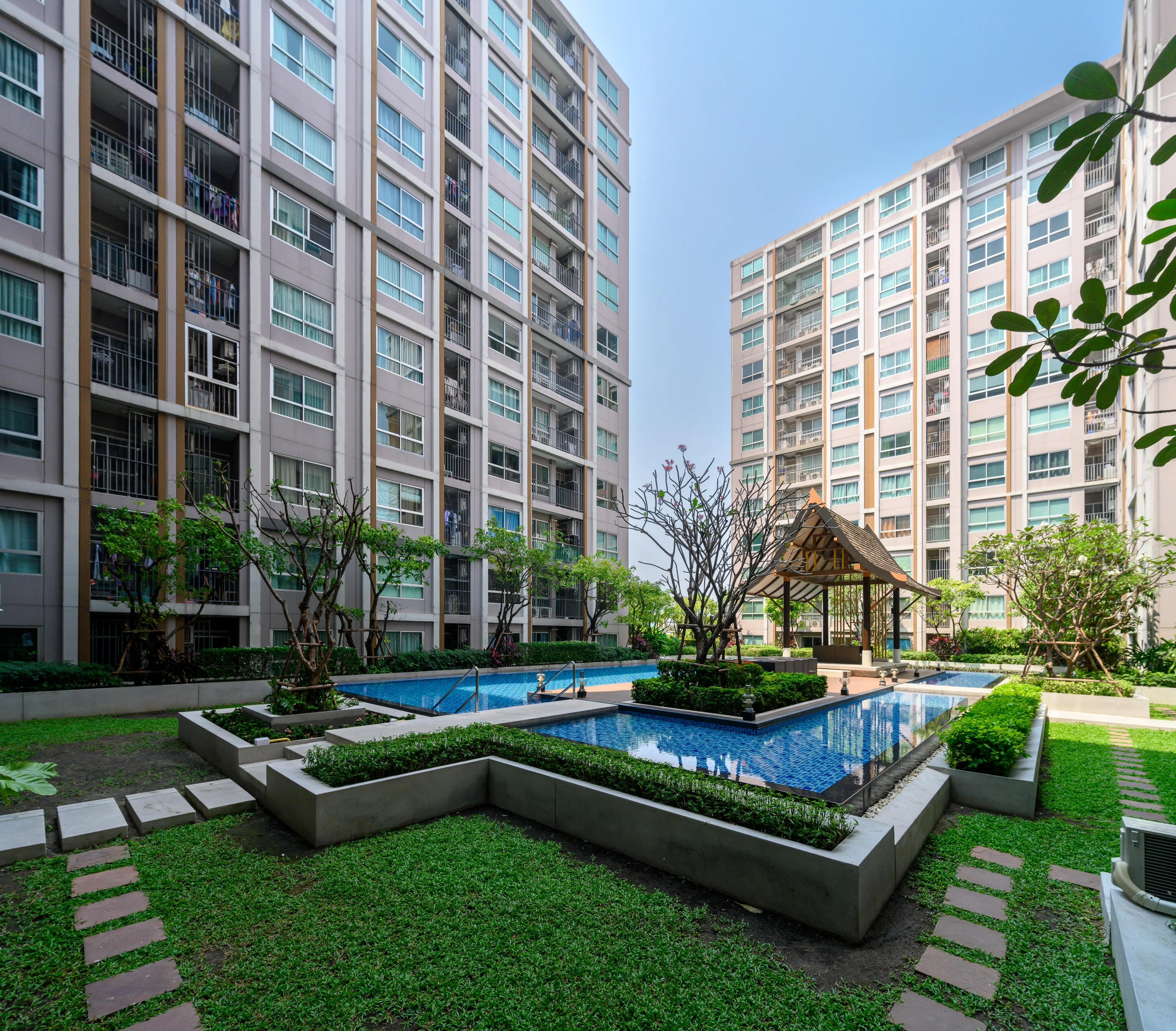 A landscaped courtyard and swimming pool surrounded by apartment buildings