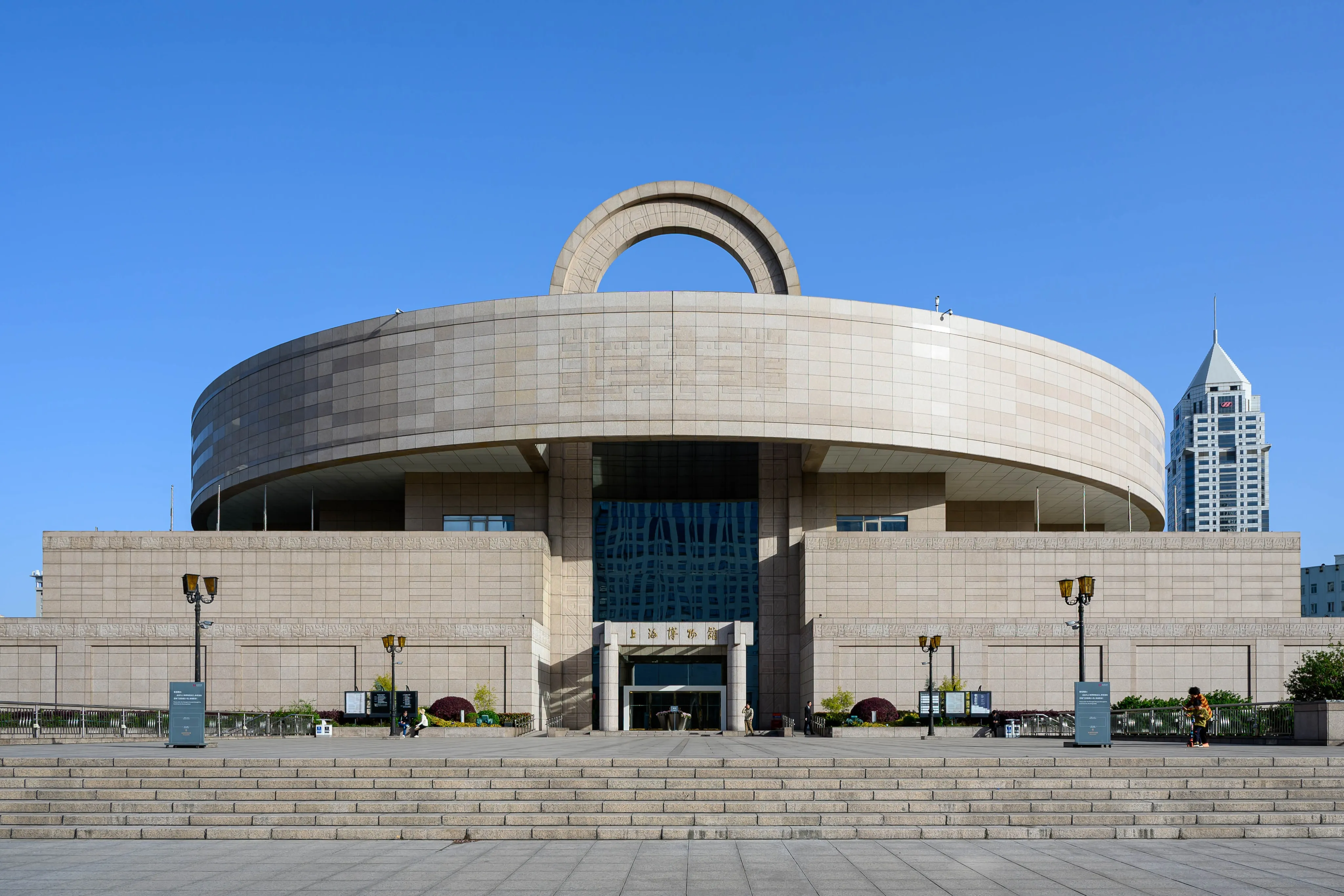 A circular concrete building beneath a blue sky