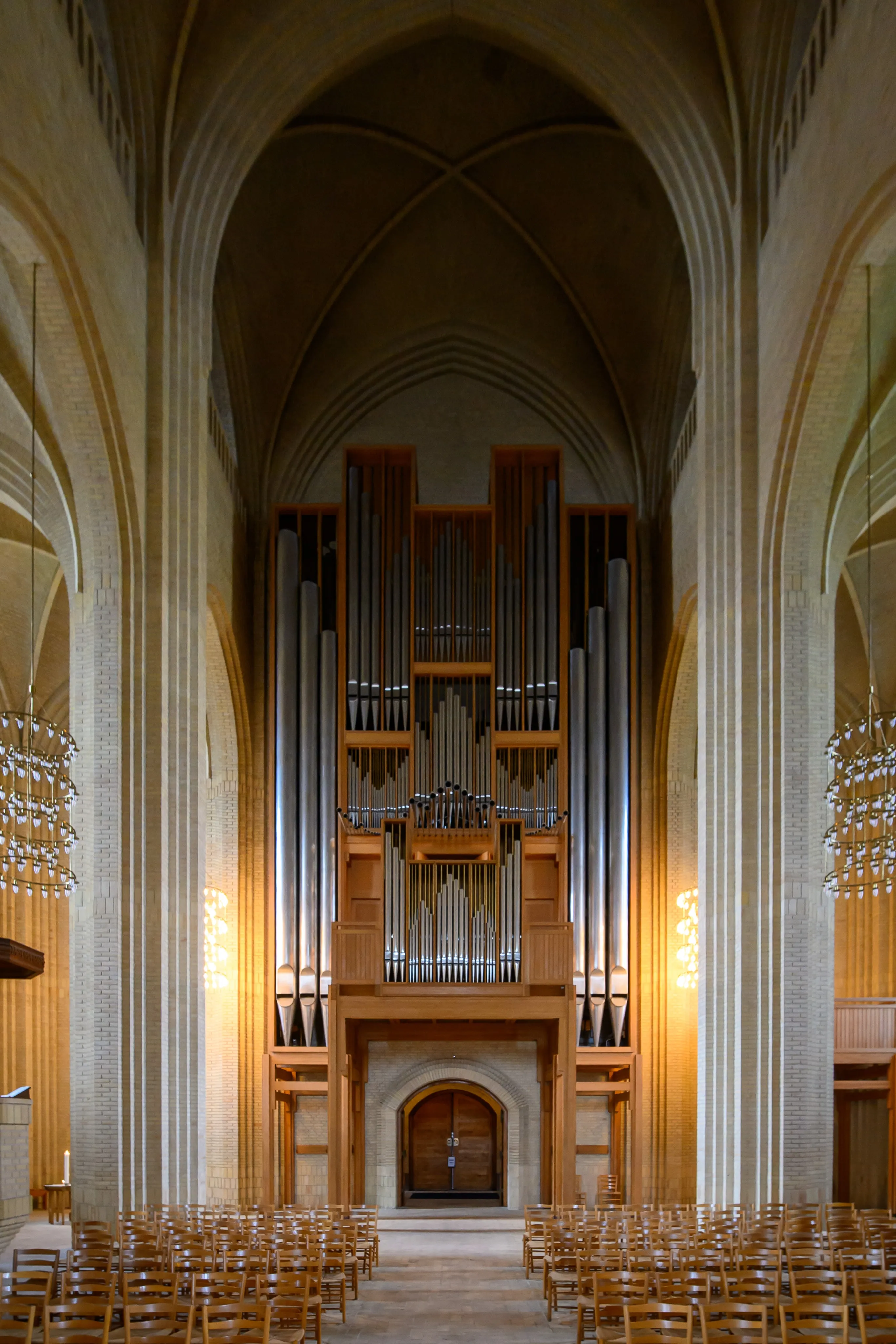 A pipe organ framed by tall brick church columns
