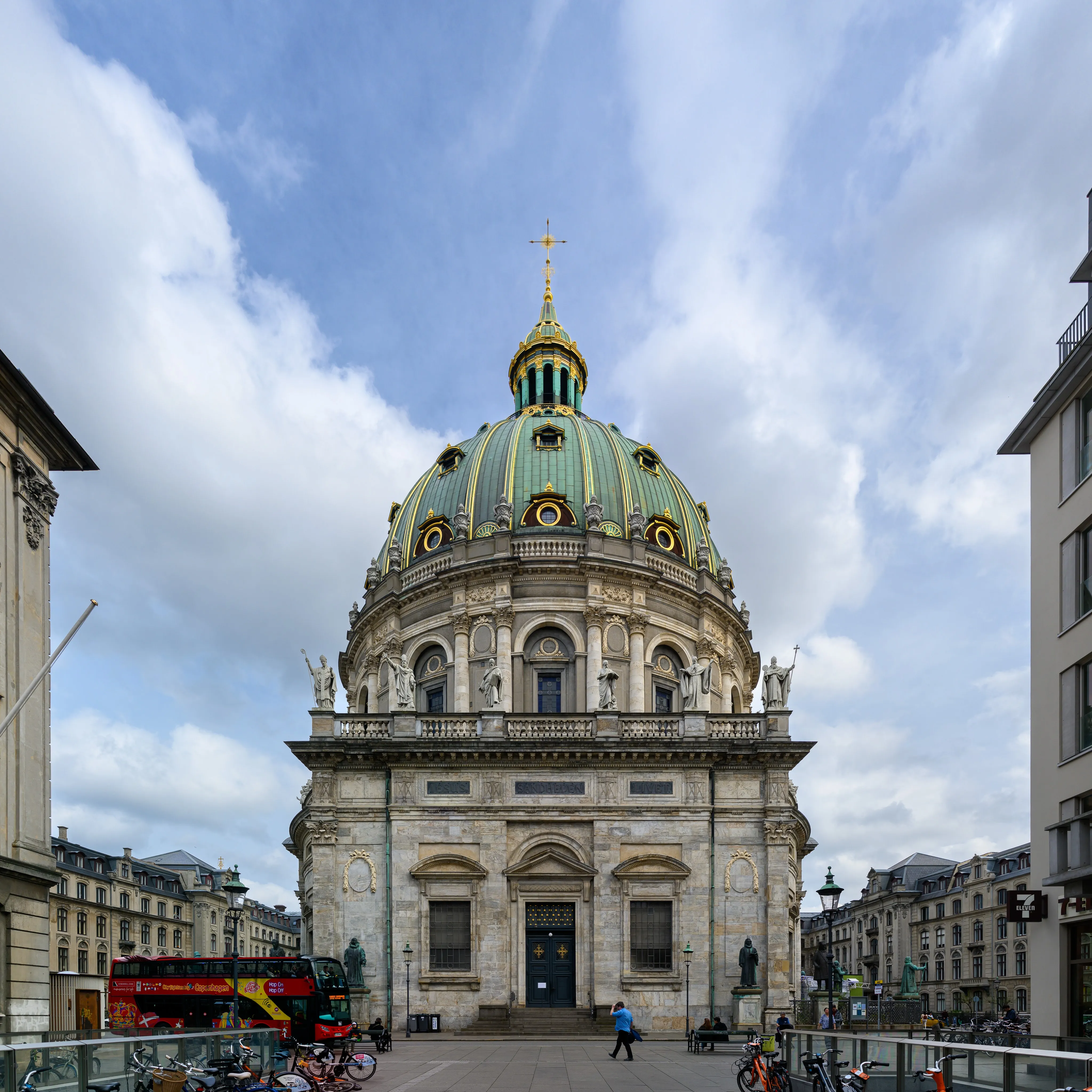 A domed church rising above a city street under clouds