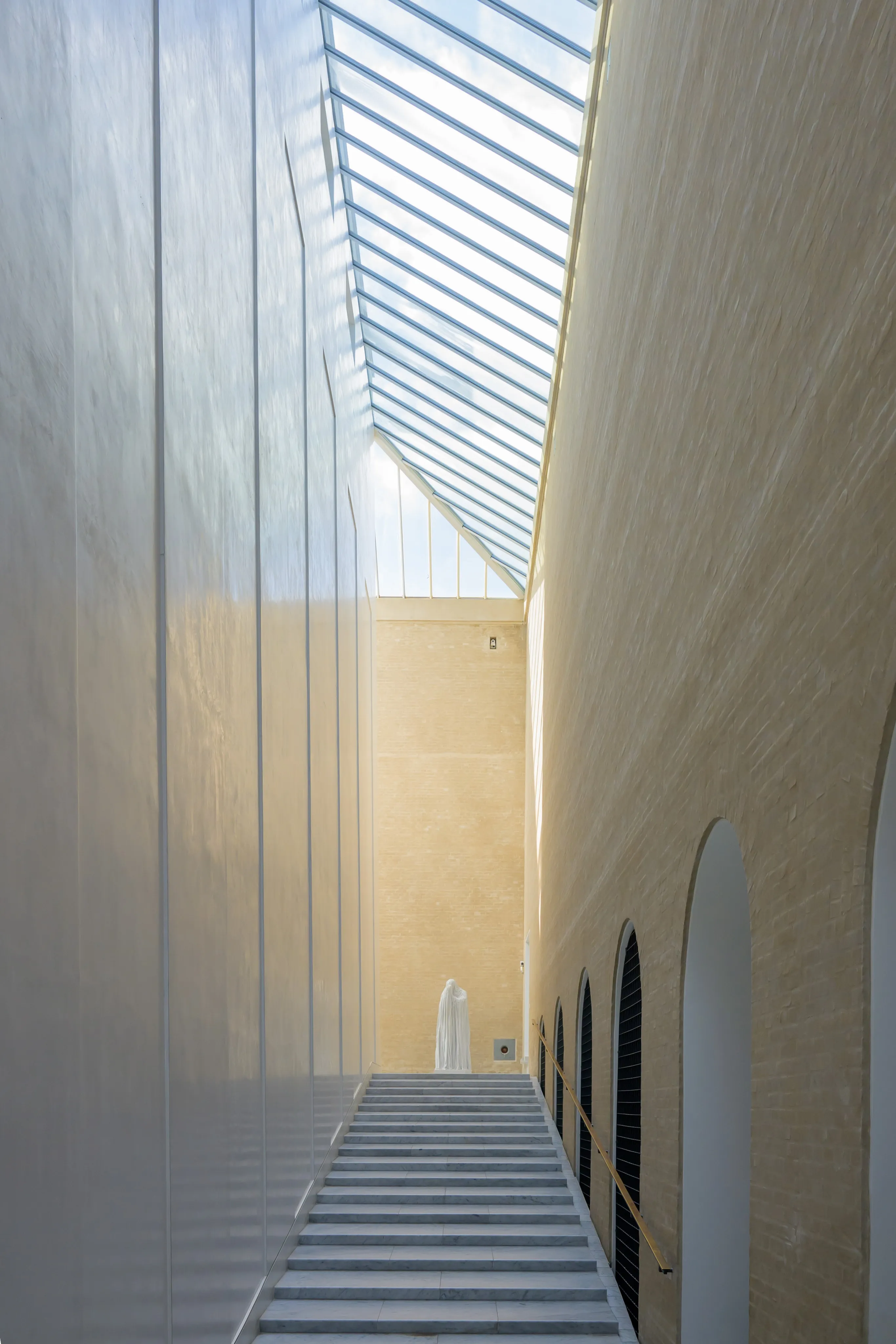 A sunlit stairway beneath a glazed roof