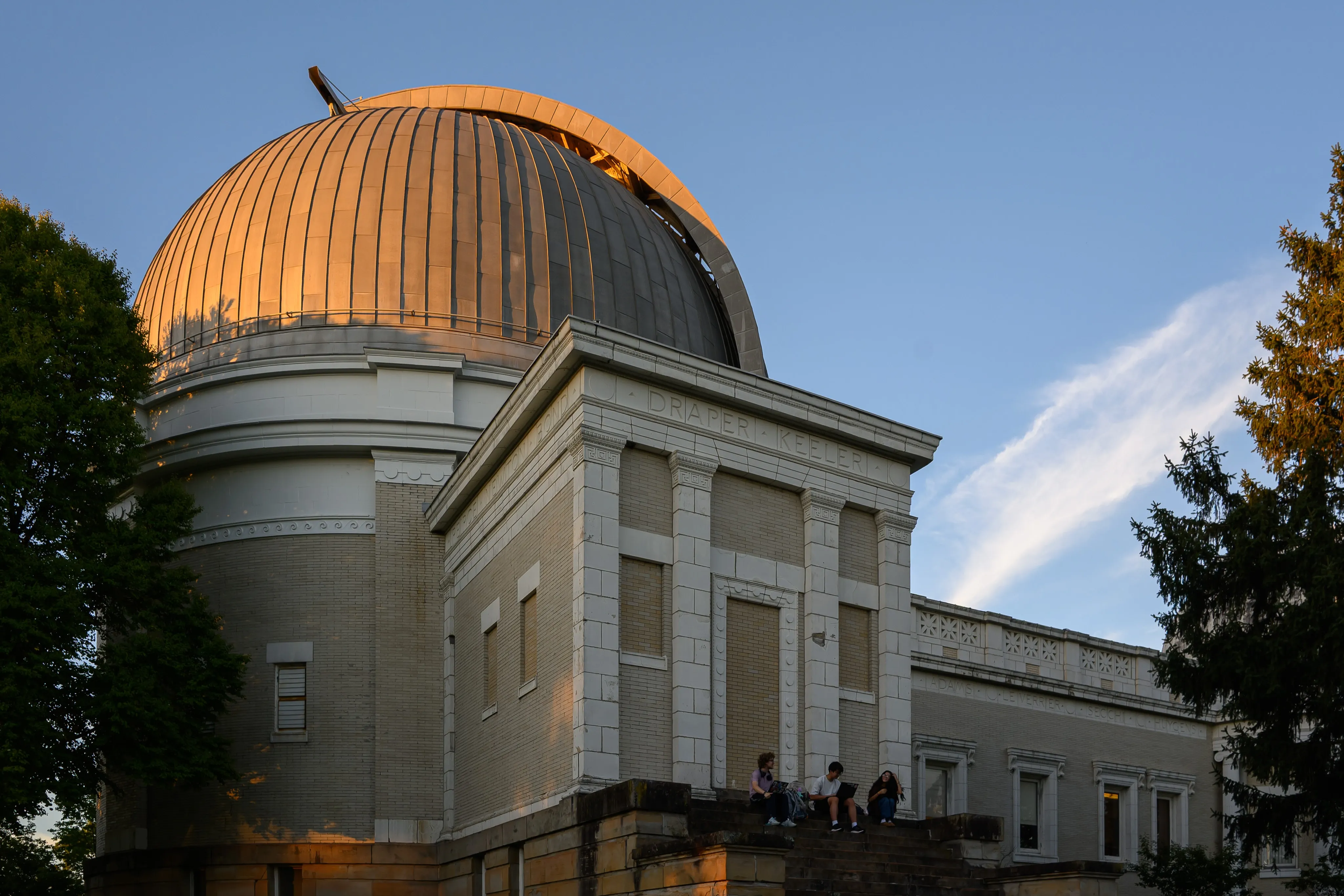 The copper dome of Allegheny Observatory glowing in the evening light above its white-columned facade.