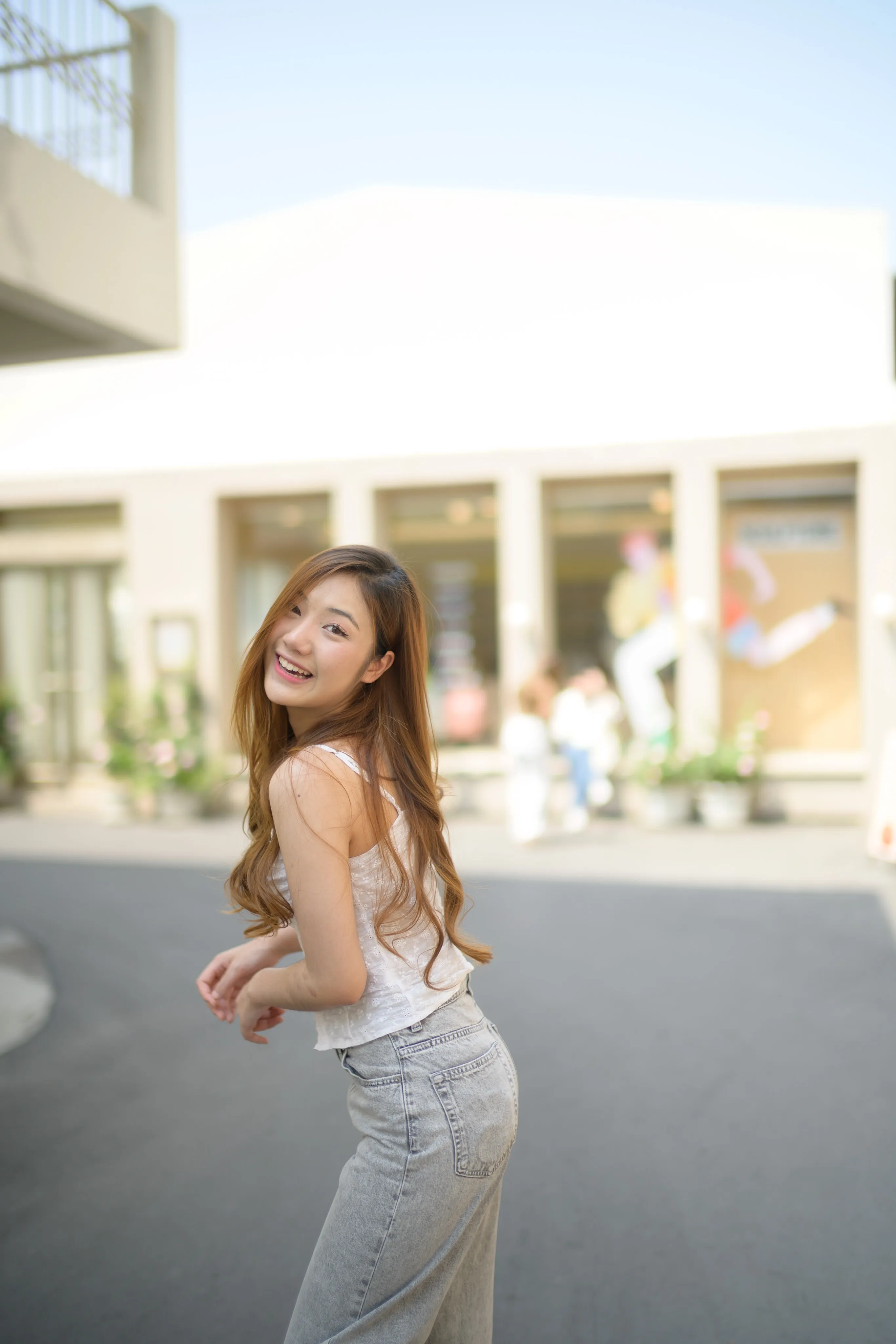 A woman glancing over her shoulder on a sunny plaza street.